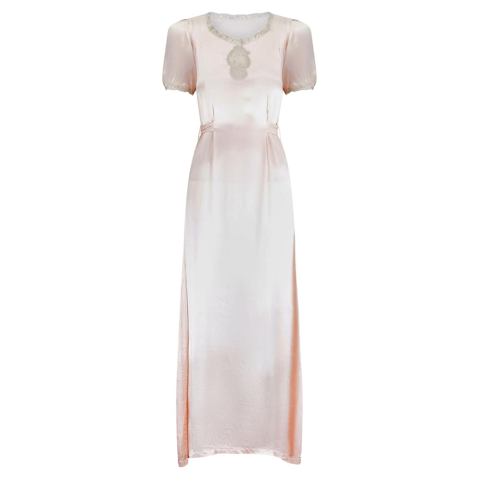 Vestido de satén rosa y encaje con lazada en la espalda, años 30