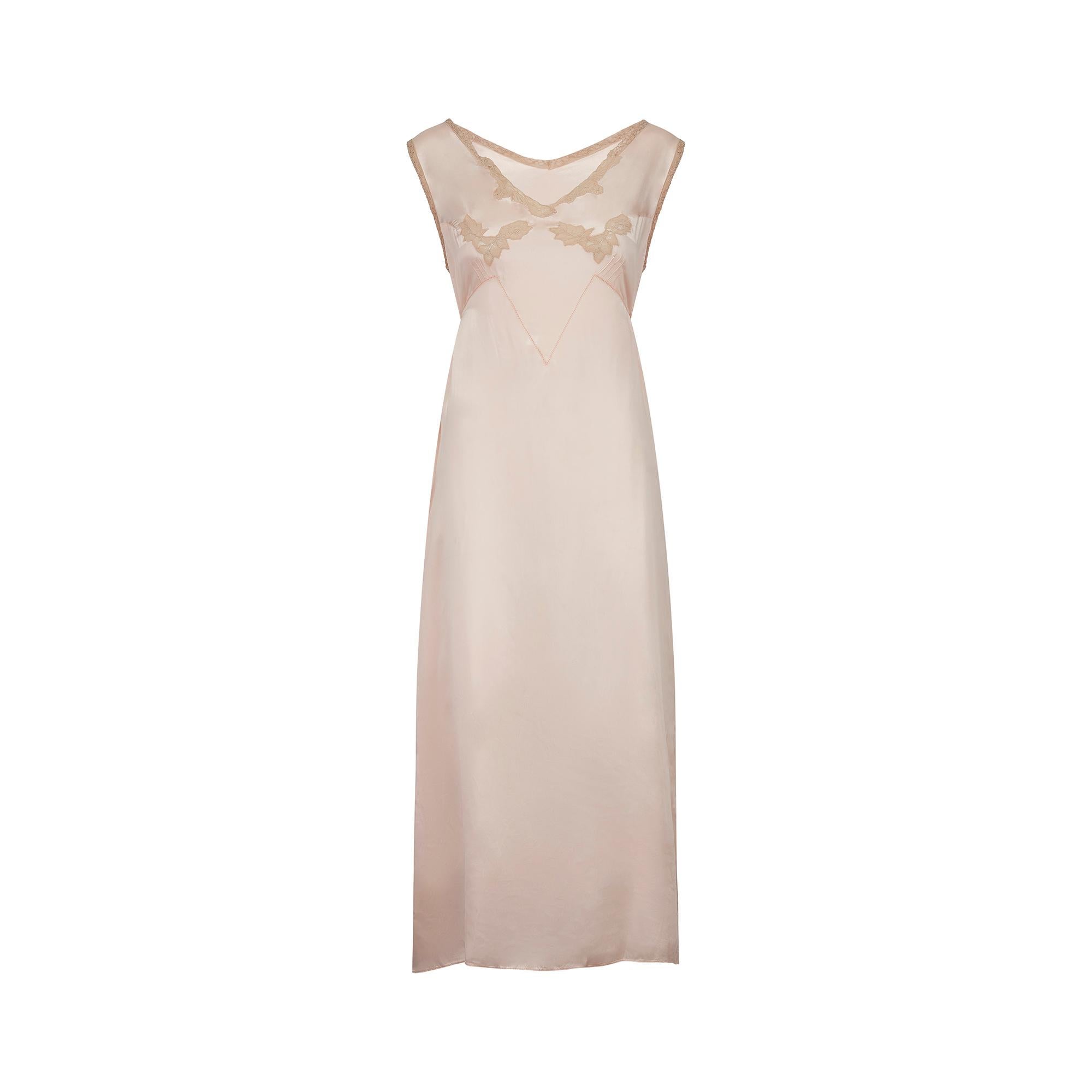 Este es un encantador vestido lencero rosa de los años 30 que tiene un conjunto de etiquetas interesantes.  La primera era la etiqueta de diseño 