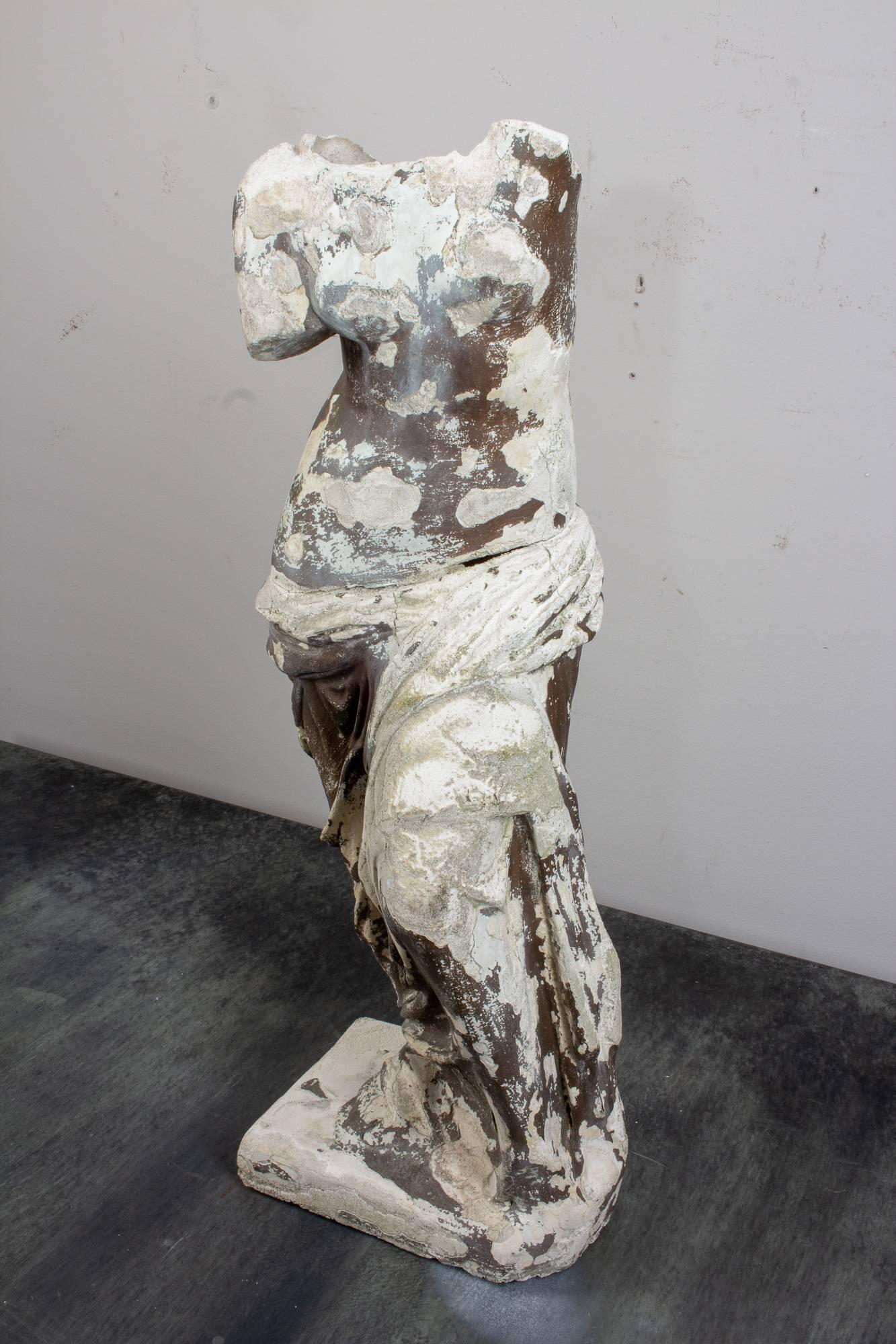 The patinated finish of this wonderful, vintage Venus de Milo cast plaster statue is truly stunning. Uncovered in France, this piece has suffered a significant break, but still evokes the same sense of beauty as the Ancient Greek statue it