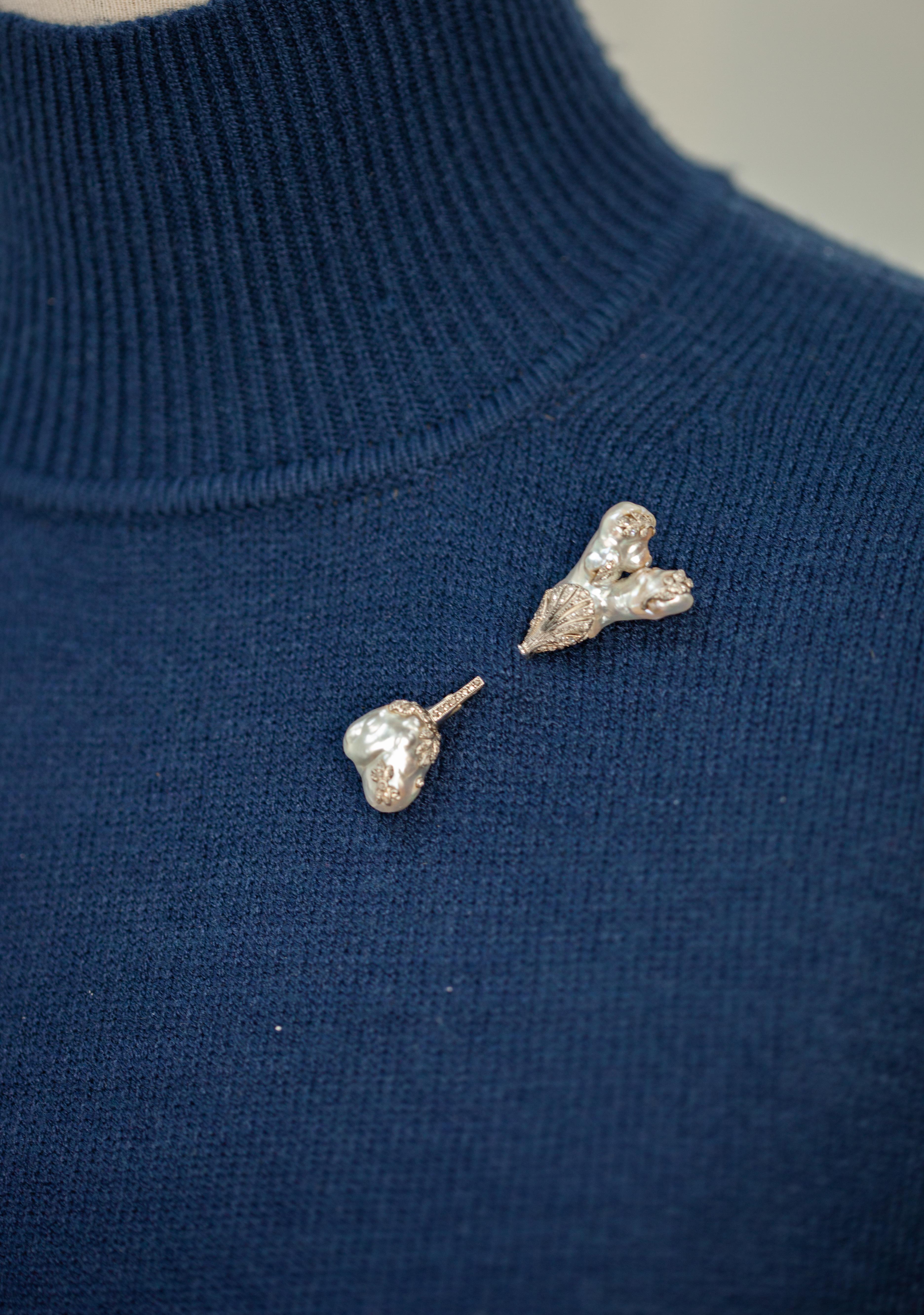 Impresionante broche jabot antiguo de platino con perlas naturales y diamantes de los años 30, engastado con dos grandes perlas barrocas y 108 diamantes talla rosa 

Medidas aproximadas:
Total ~ 21mm x 65mm

Sello: NA
Pureza del oro comprobada