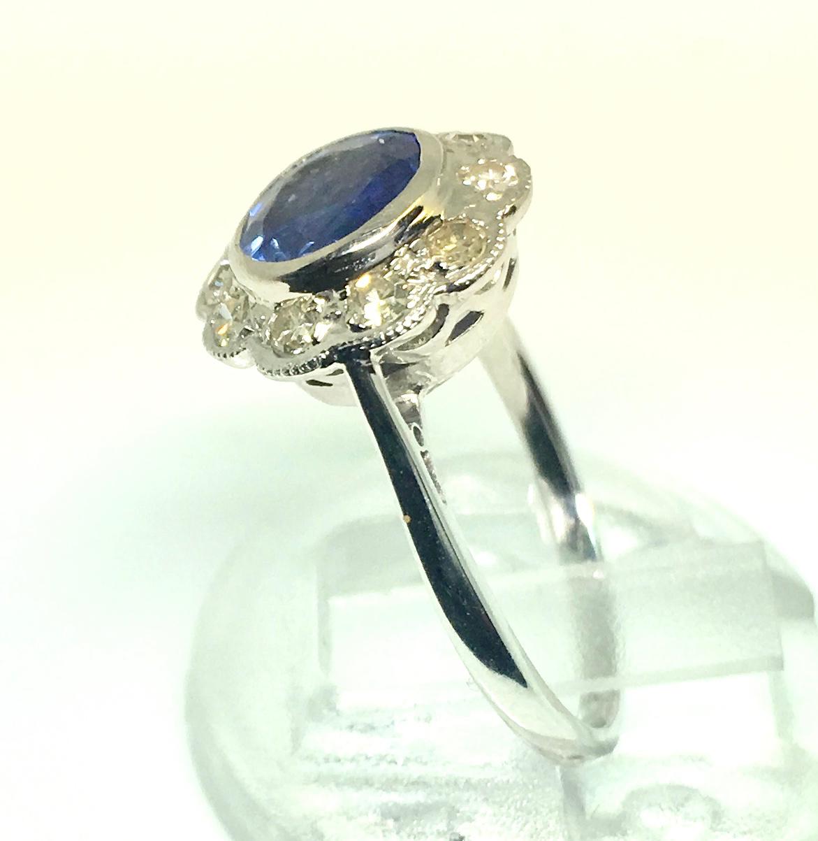 A cute little round Burma sapphire an diamond 1930s cluster platinum ring. It weighs approximately 1ct surrounded by 10 old cut diamonds. The colour of the diamonds range from white to off colour Vs to si clarity. The natural sapphire is certified