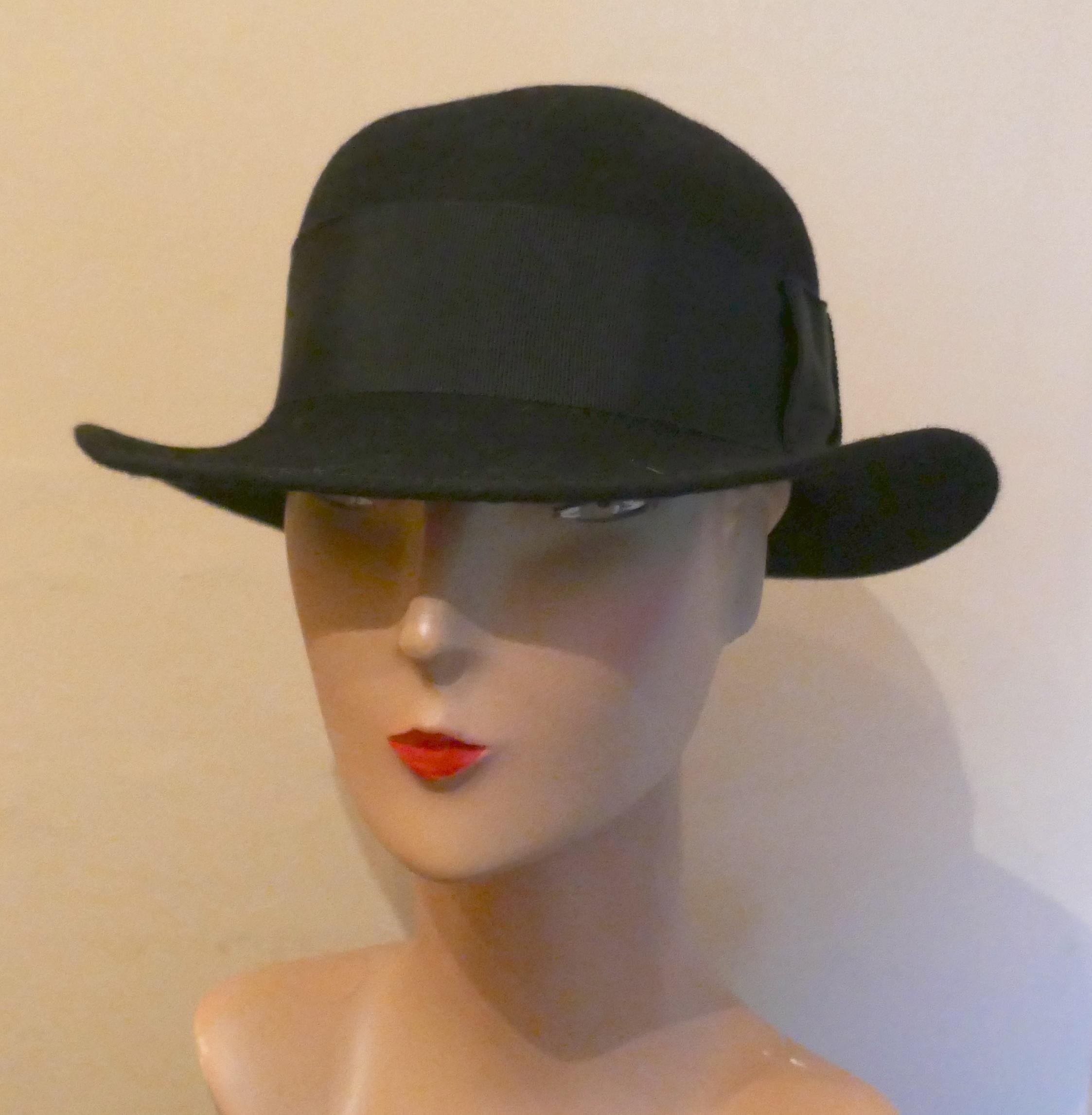 1930s Black Cloche Felt Hat 

A Great Classic piece in great condition, the Hat has a 2” twill hat band and measures 57cm around the inside band
This is a genuine vintage piece and in good condition.  
B23