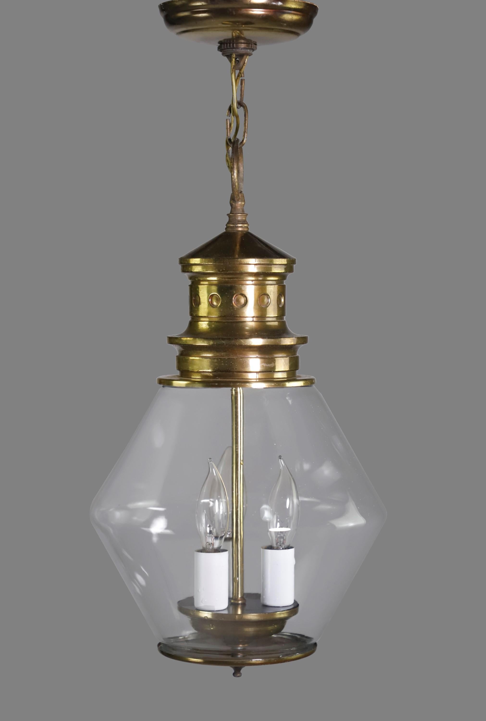 1930s Railroad style brass pendant light. The unusual clear shade is hand blown glass. The fixture itself is made from brass and features three candelabra light sockets. Cleaned and restored. Please note, this item is located in our Scranton, PA
