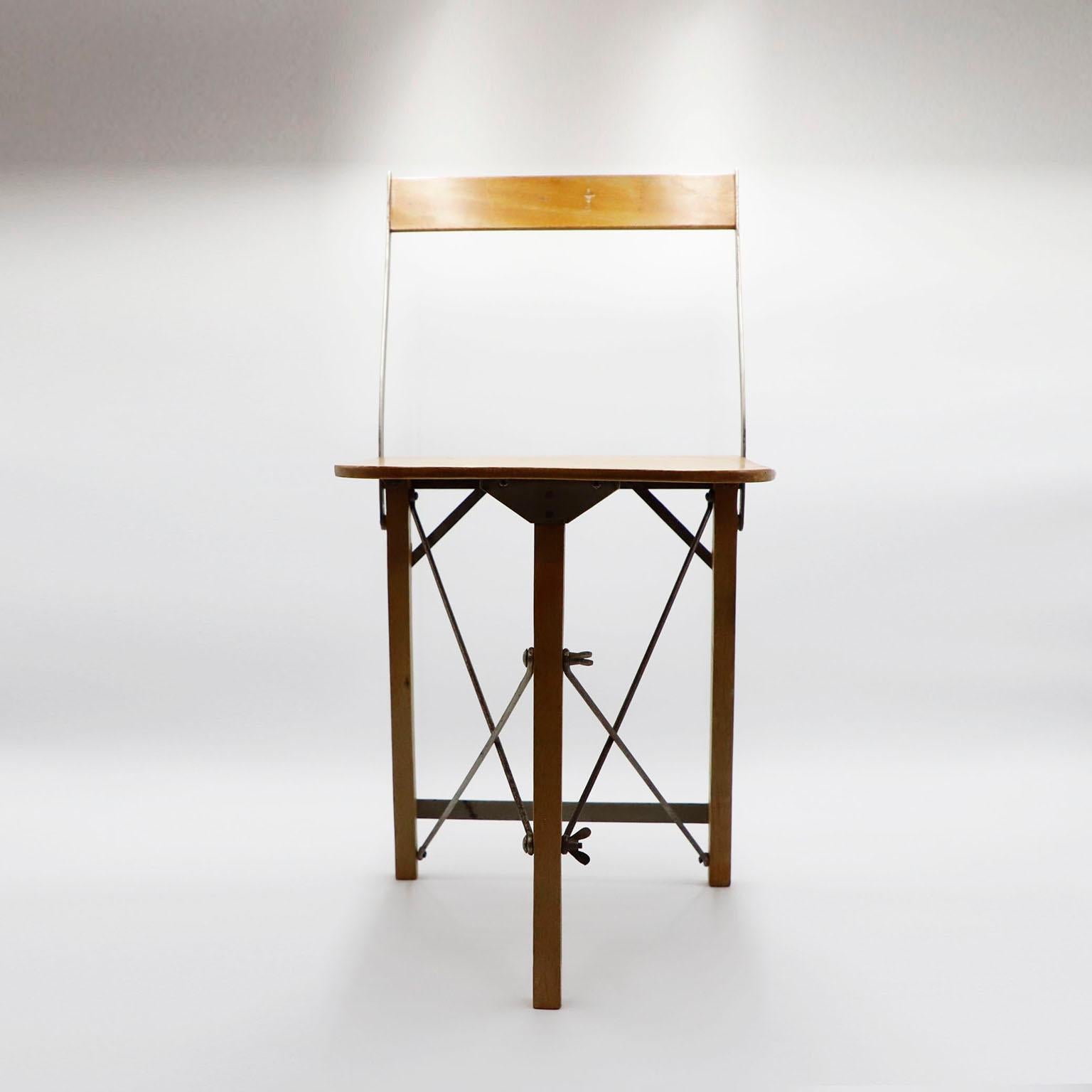 Circa 1930. We offer this beautiful folding children chairs made in plywood and iron structure. Fantastic utilitarian chairs that cleverly fold down so you can store them tidily away. All fold nicely and are in good condition, with just minor signs