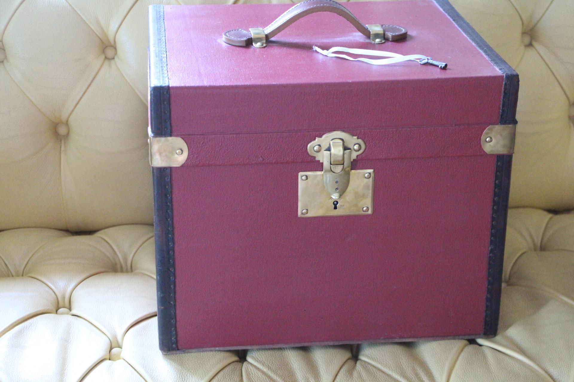 This very nice red canvas and leather hat box features leather trim and leather top handle as well as solid brass locks,clasps and studs.It still has got its working key.
It is very elegant and it has got a very rich and warm patina.
Its interior