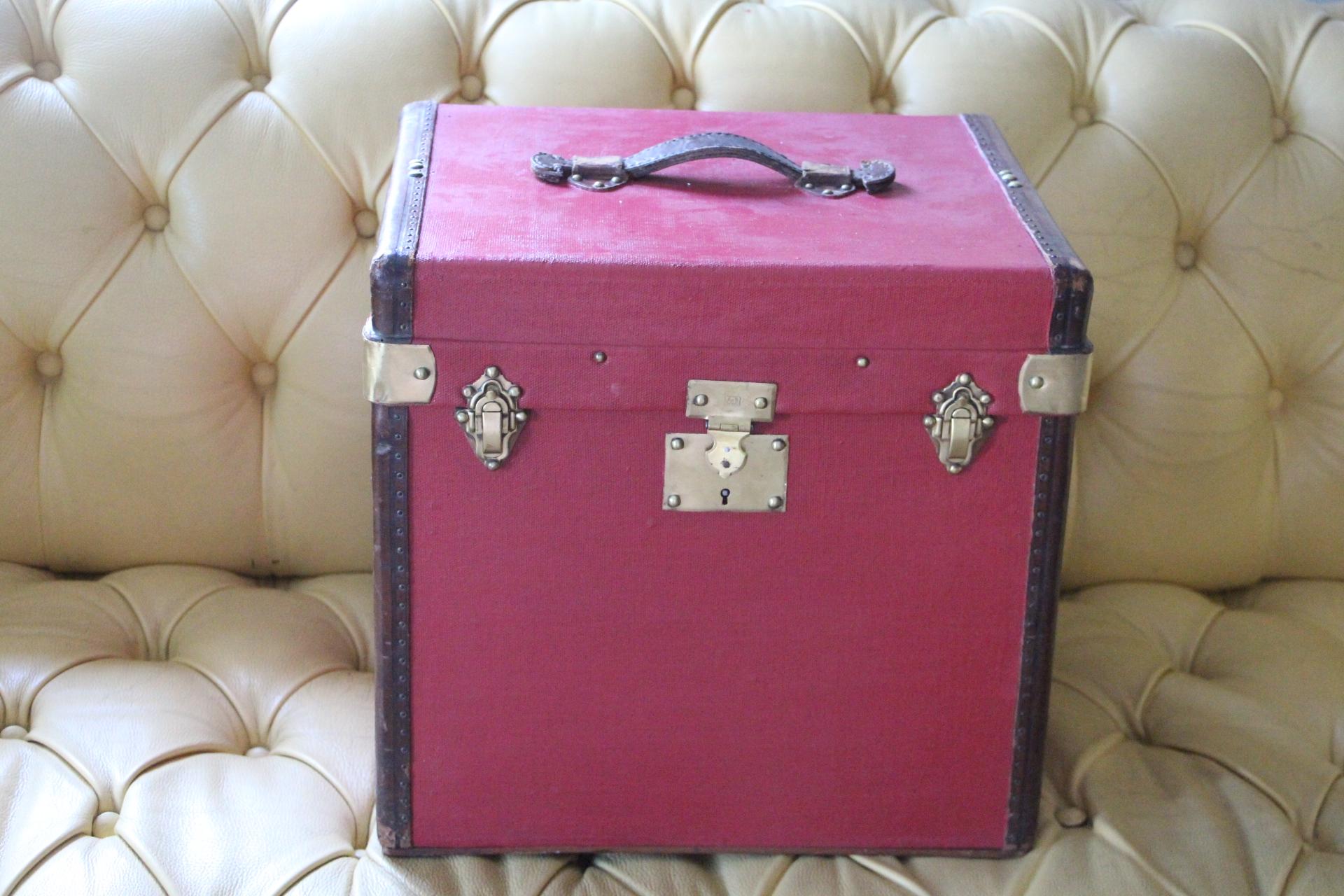 This very nice red canvas and leather hat box features leather trim and leather top handle as well as solid brass locks, clasps and studs.
It is very elegant and it has got a very rich and warm patina.
Its interior has been relined a while ago in