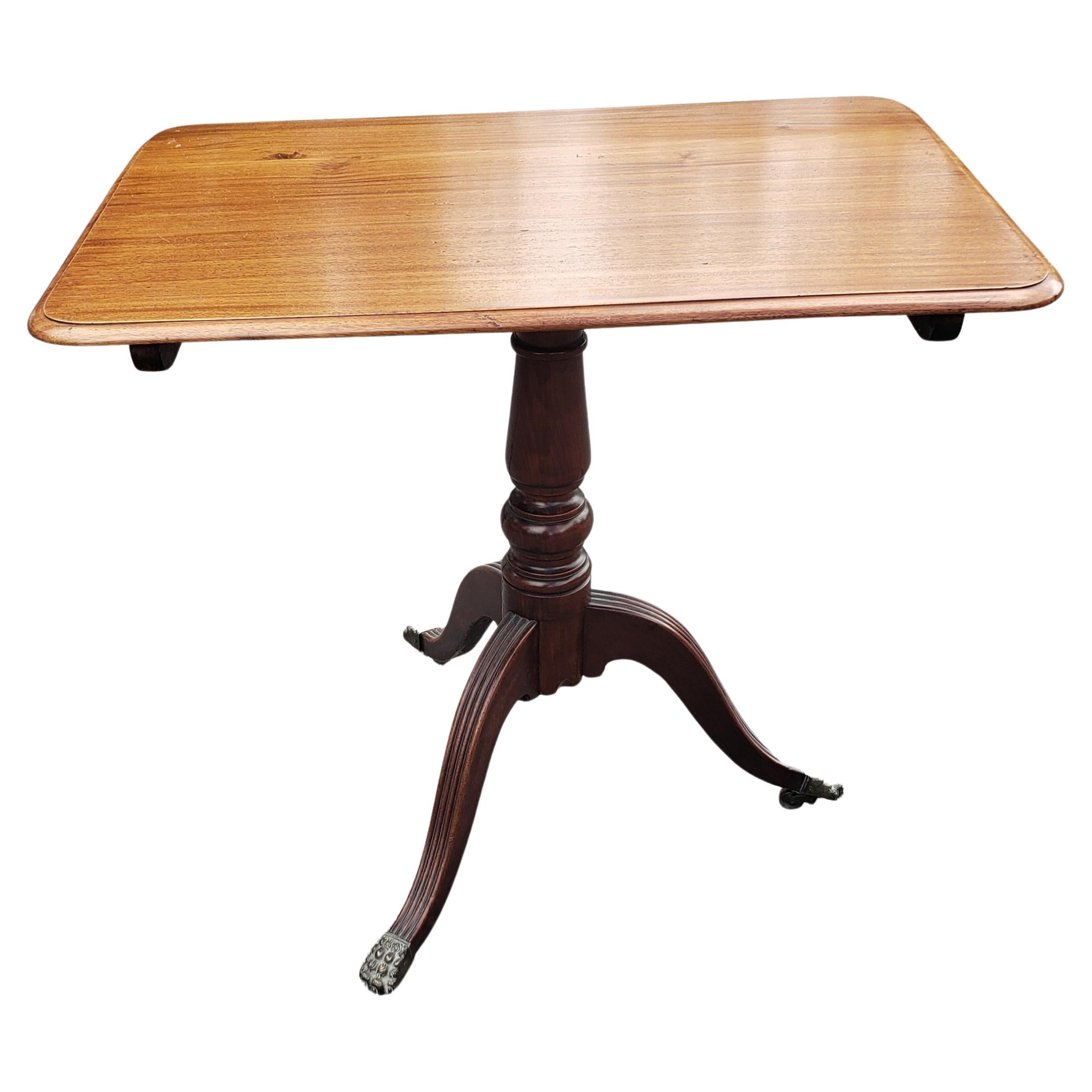 A 1930s Regency Mahogany Tilt-Top Tea Table with Brass Paw Feet on Wheels in very good vintage condition. Table has been recently refinished and looks and feel great. Measures 30