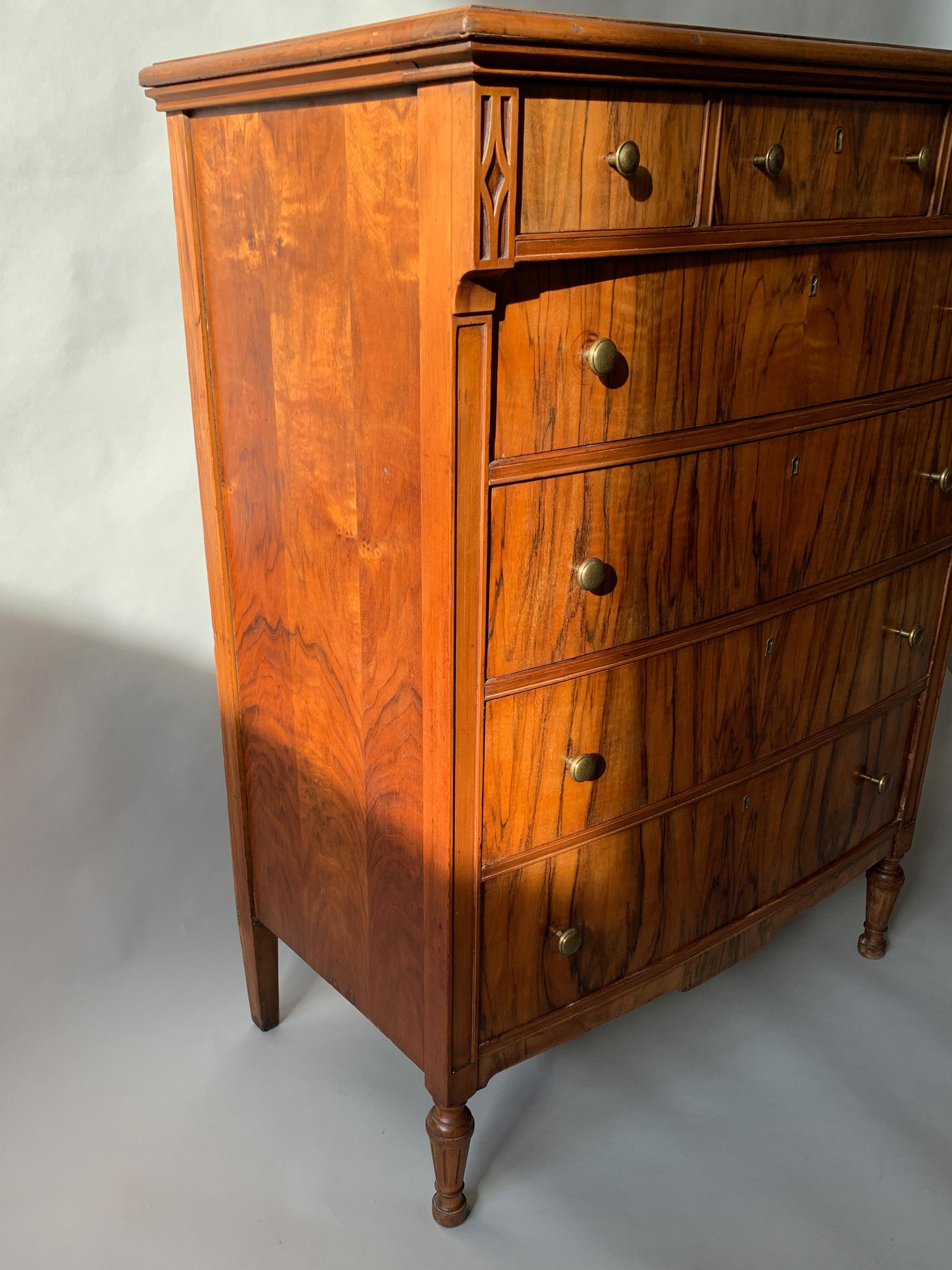 1930s rosewood 7-drawer English dresser with brass knob and keyhole details. Carved wood detailing on corners, tapered legs and a beautiful veneer. Sturdy.