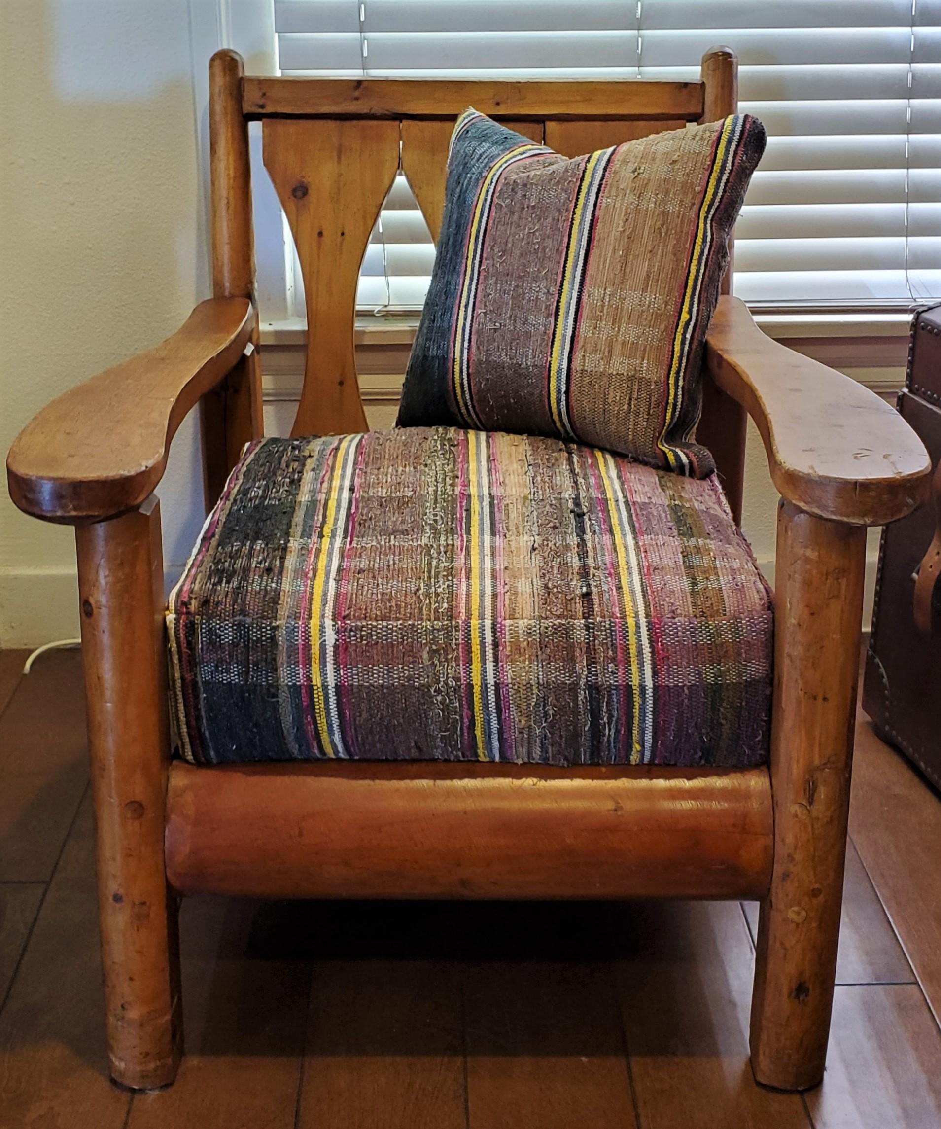 This Rittenhouse rustic old pine arm or club chair from a cabin is upholstered in 19thc rag rug fabric. The condition is very strong and sturdy condition. The construction is wood peg and very strong. The seat and cushions are in fine condition and