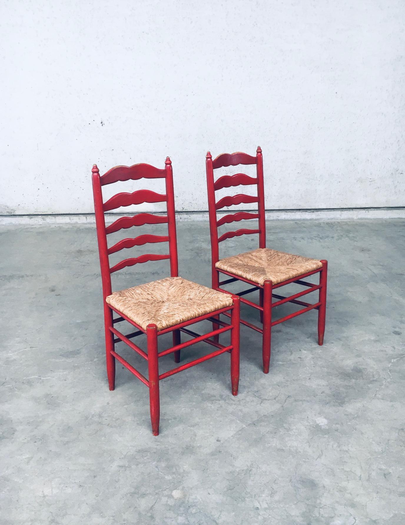 Ensemble de chaises vintage rustiques à haut dossier en échelle en bois laqué rouge et jonc. Fabriqué en France, époque 1930. Chaises à haut dossier en échelle de conception classique avec des fuseaux en forme de moustache sur le haut dossier. Le