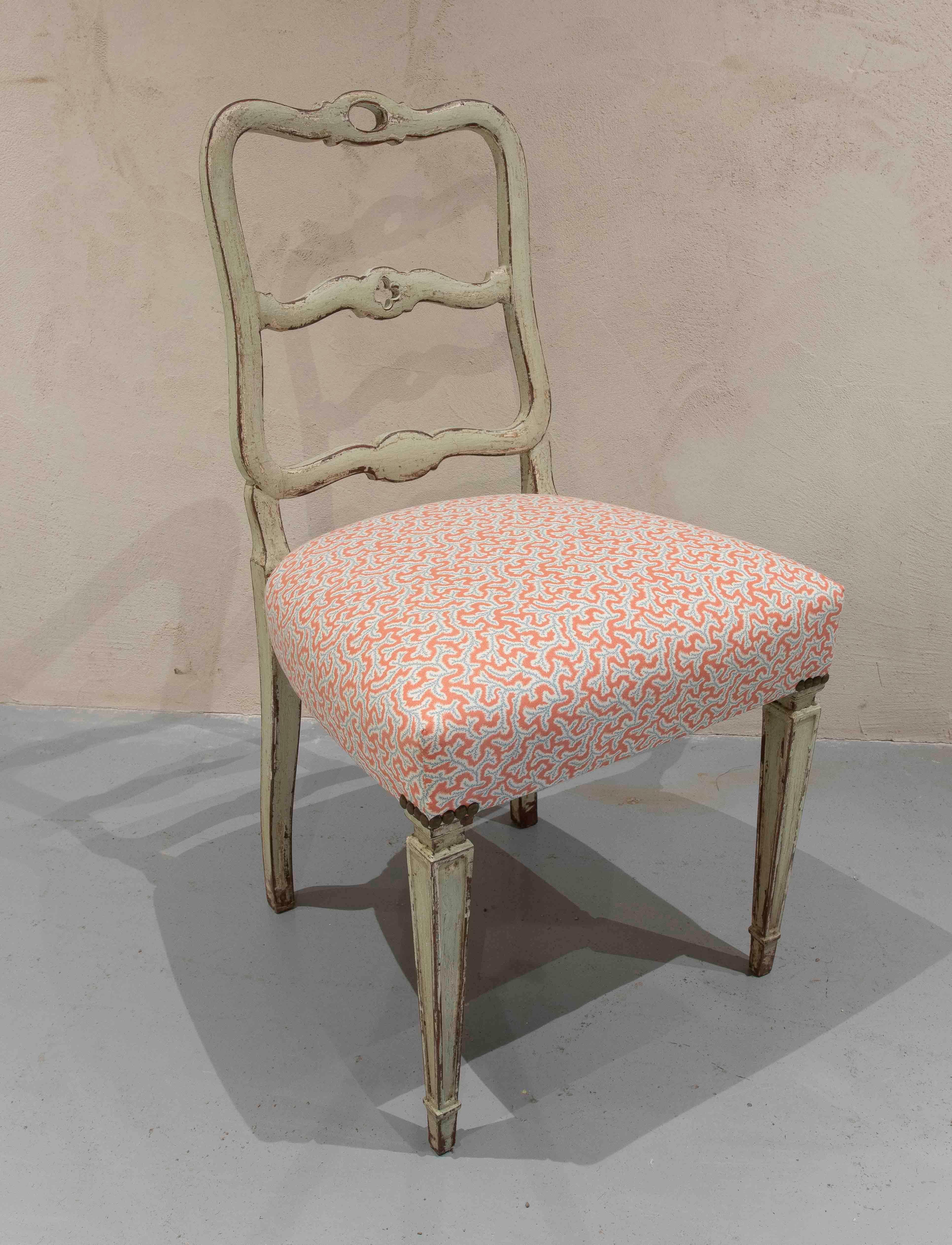 Un ensemble de six chaises de style provençal avec un cadre en bois sculpté et une finition en blanc cassé vieilli. Les dossiers incurvés à double barre apportent une légèreté visuelle, tandis que les sièges ont été retapissés dans un tissu à motifs
