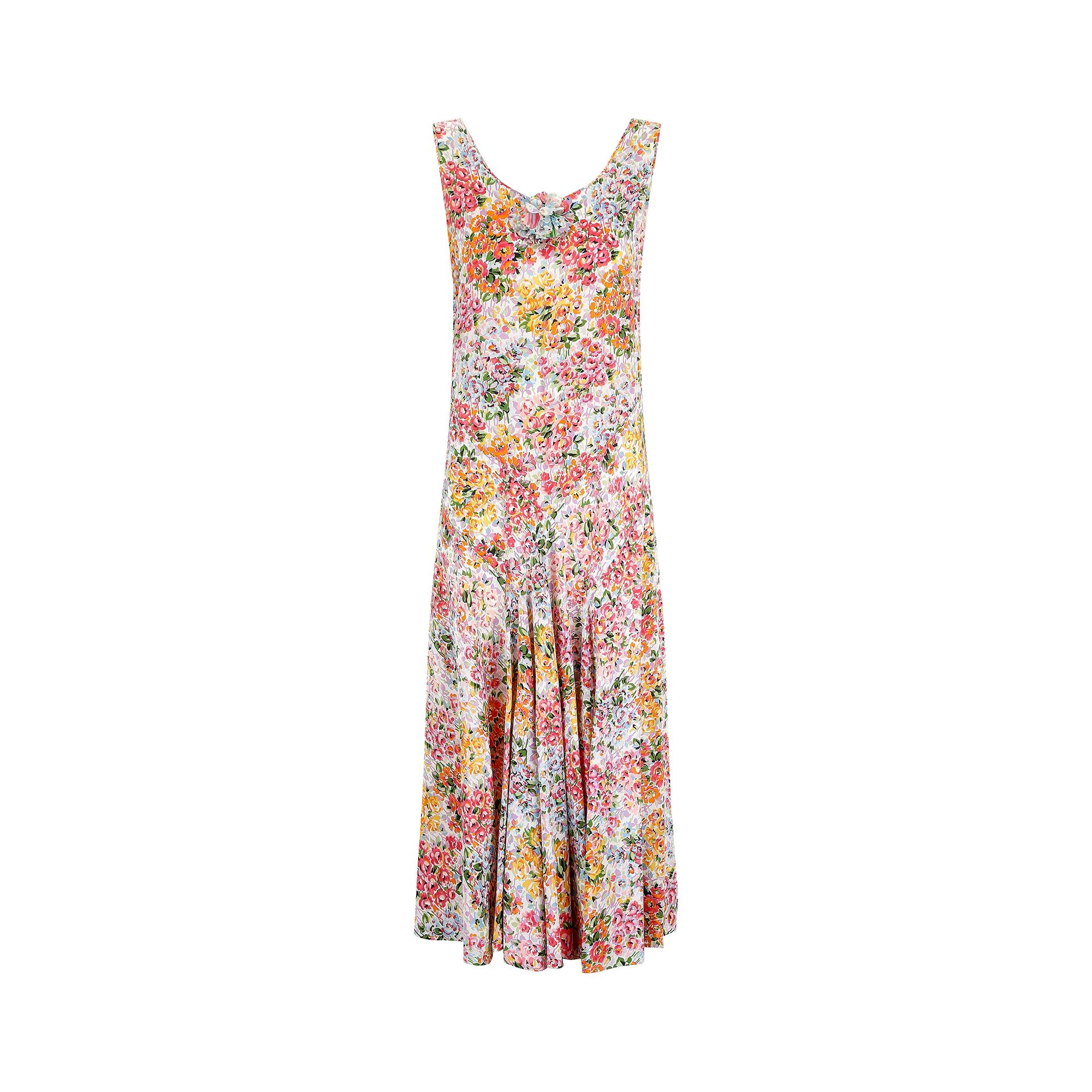 1930s silk bias cut dress in a beautiful 'cottage' style floral print, perfect for spring and summer. It features a rounded neckline with a front floral applique for an added feminine touch. The dress has a straight cut torso with inverted waistband