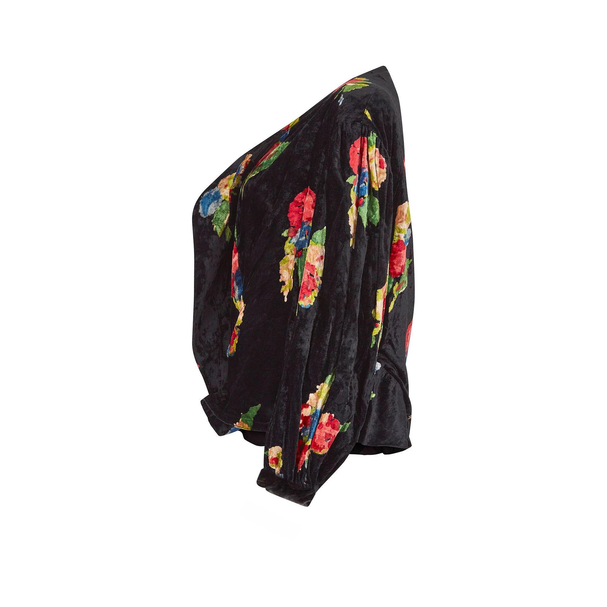 This 1930s jacket has a superb print and the velvet fabric is of painterly florals in an assortment of rich jewel tones set against an inky black background. The sleeves are cut to a bell-shape with the fabric gathering at the shoulders and the