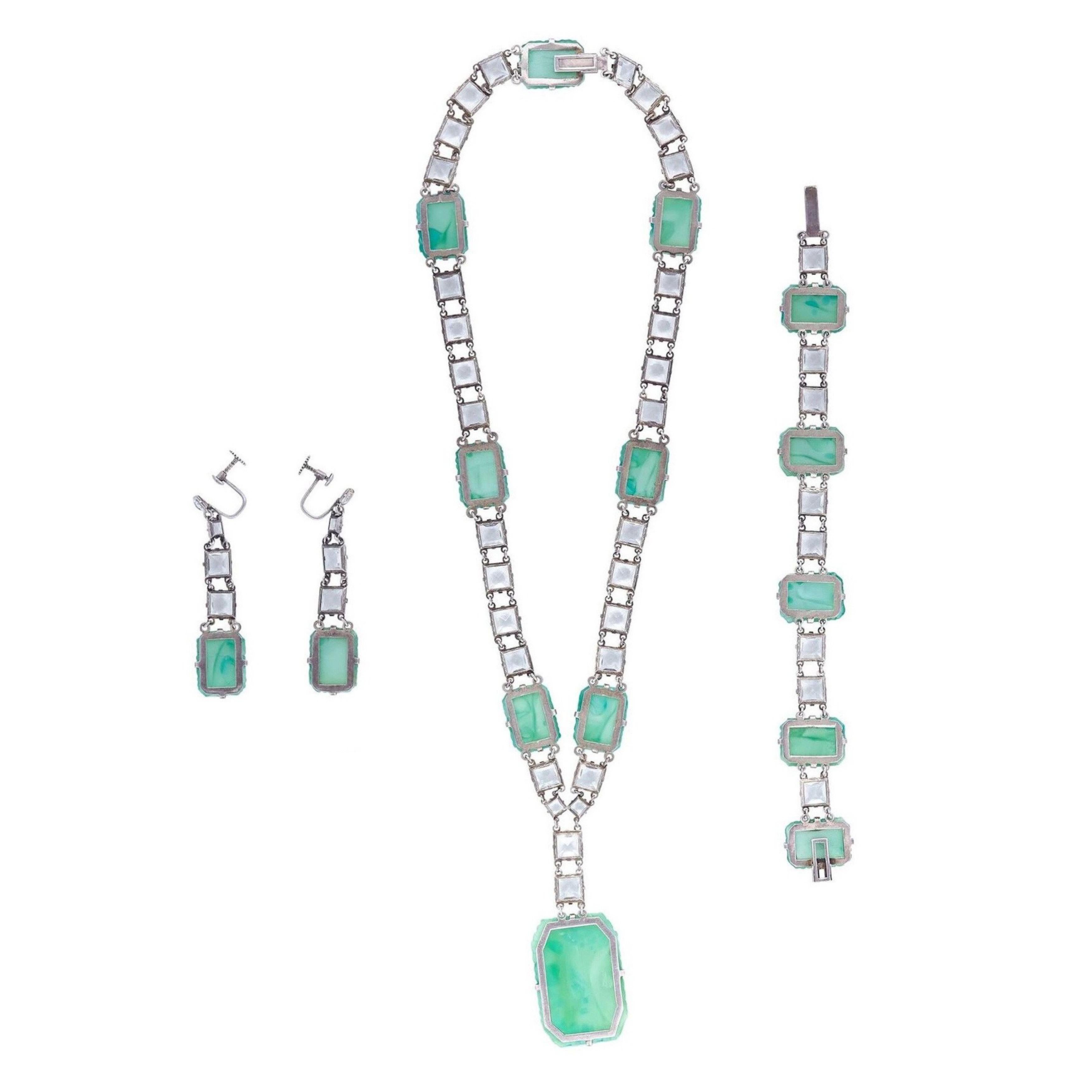 This exquisite 1930s Art Deco Peking Glass 3 piece set with prong set rock crystals is comprised of drop earrings, matching bracelet and necklace with a large drop pendant, and is in absolutely beautiful condition. Peking Glass is very collectable
