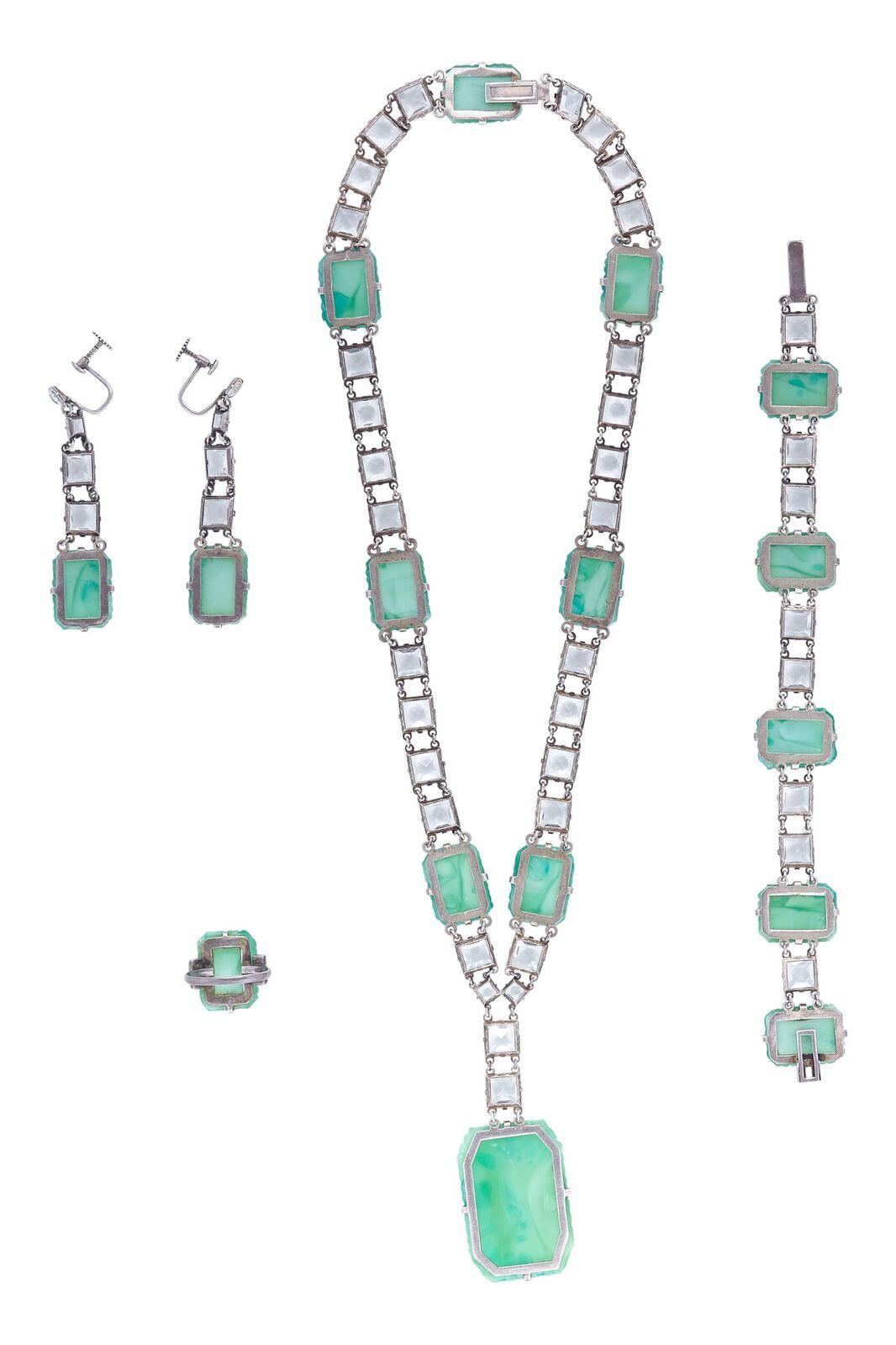 This exquisite 1930s Art Deco Peking Glass 4 piece set with prong set rock crystals is comprised of a ring, earrings, matching bracelet and necklace with a large drop pendant, and is in absolutely beautiful condition. Peking Glass is very