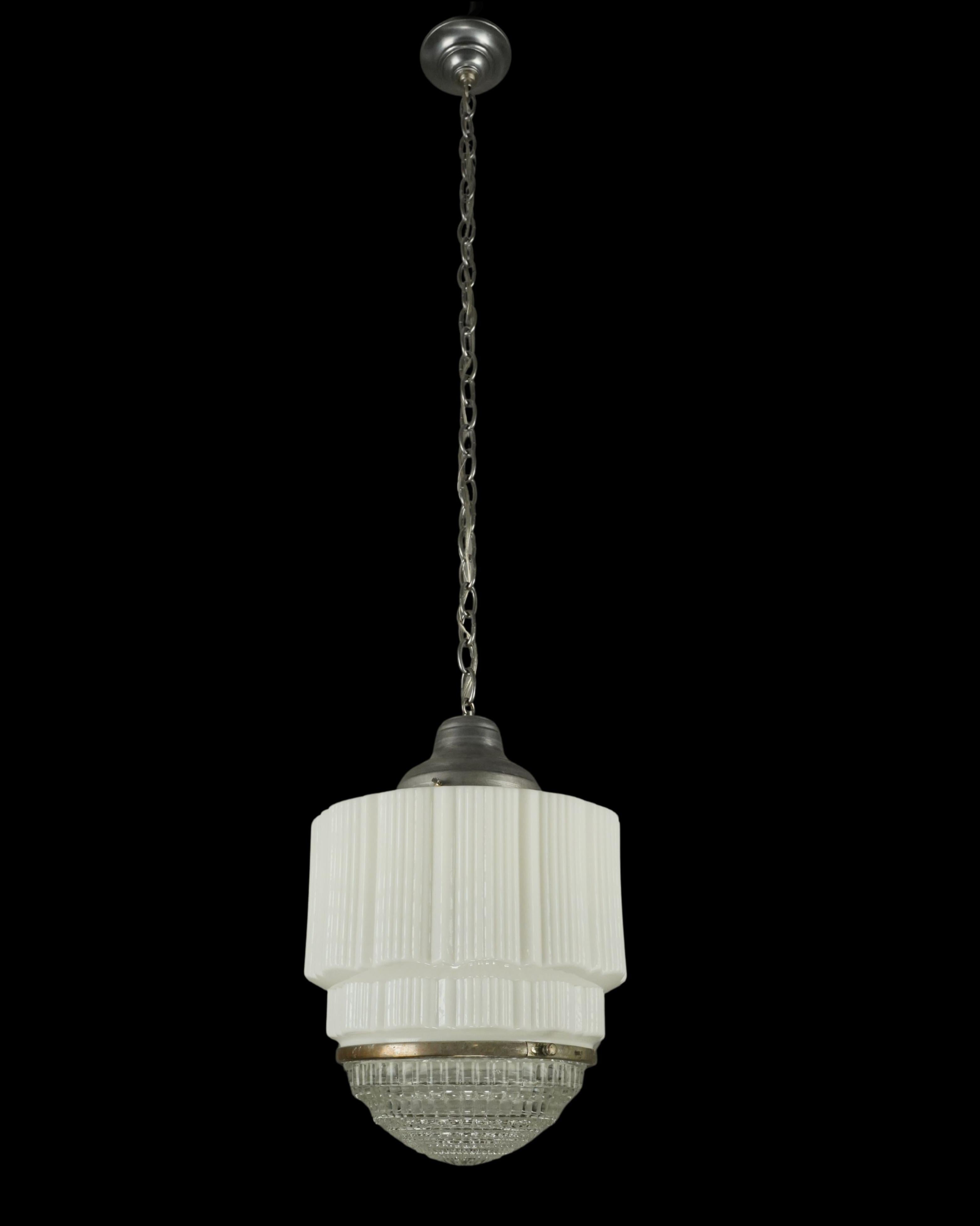Lámpara colgante de estilo Art Déco con globo de cristal de leche blanco, lente de cristal de Fresnel transparente y enganche de cadena de acero cepillado. Requiere una bombilla estándar Edison de casquillo mediano. Limpiado y restaurado. Buen