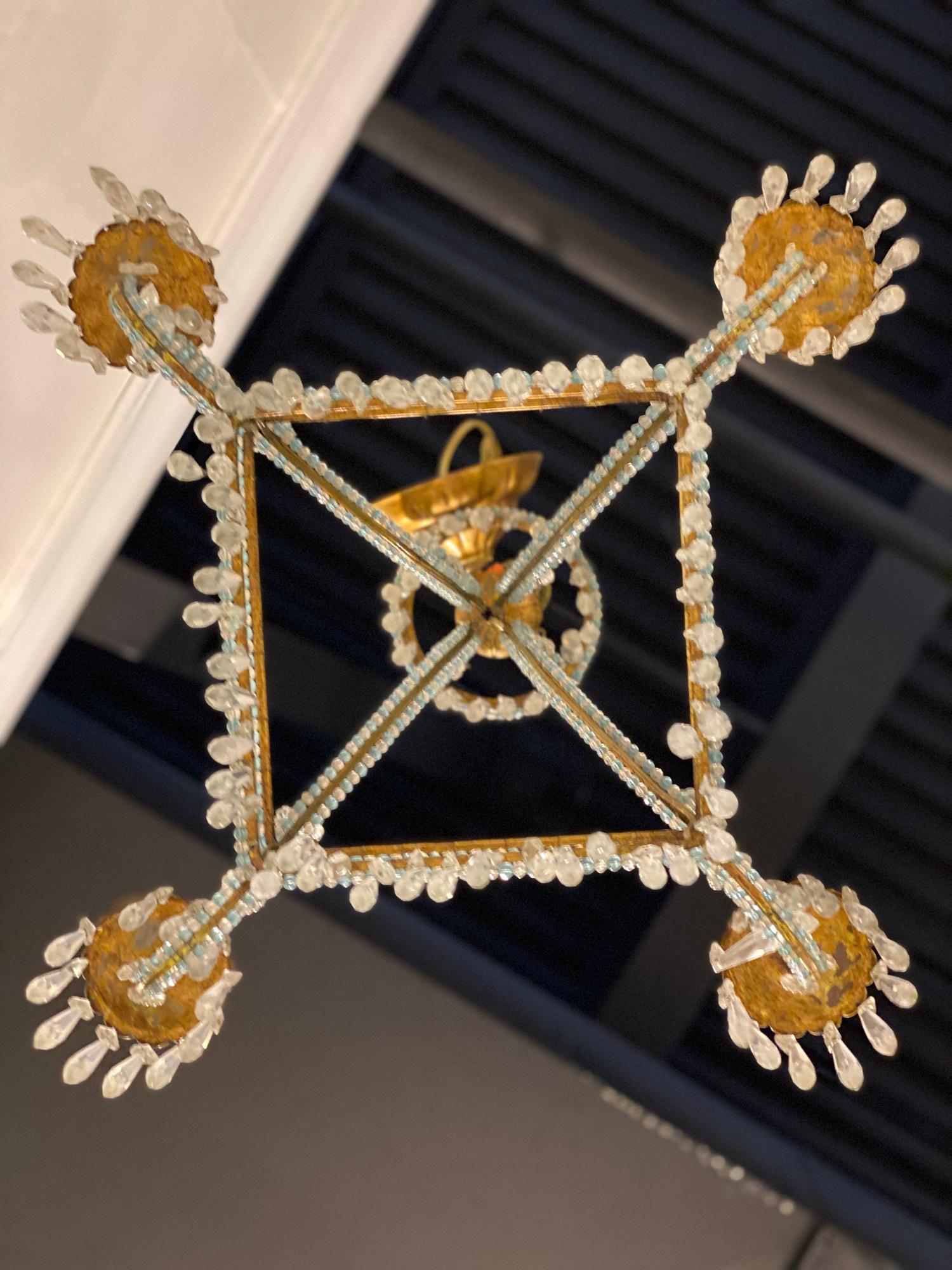 Ein italienischer, quadratischer Kronleuchter aus vergoldetem Metall aus den 1930er Jahren mit weißen und blauen Perlenkristallen am Korpus und hängenden Kristallen. Hat 4 Lichter