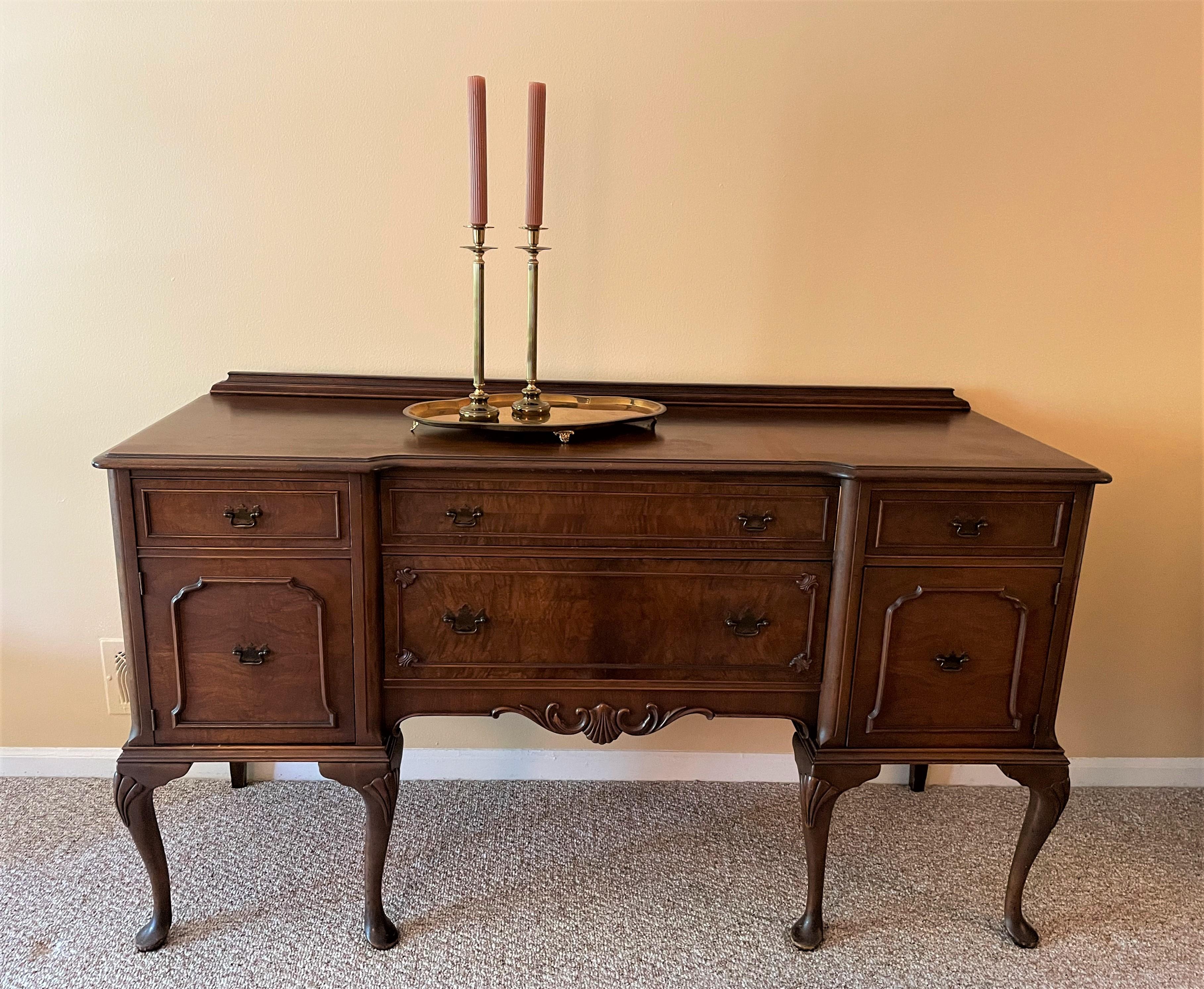 This is a stately piece from the 1930s, and one that is in extraordinarily excellent condition. It is a rare find having been made from solid walnut with burled wood on the front drawers. The wood (including the surface of the buffet) is beautifully