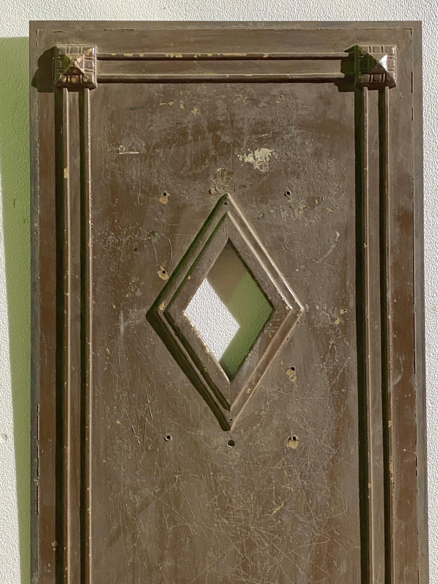 1930s steel elevator door featuring bronze hardware details and a small diamond shaped window done in an Industrial size. Narrow width. Please note, this elevator door is 1/8 inch thick. This can be seen at our 400 Gilligan St location in Scranton,
