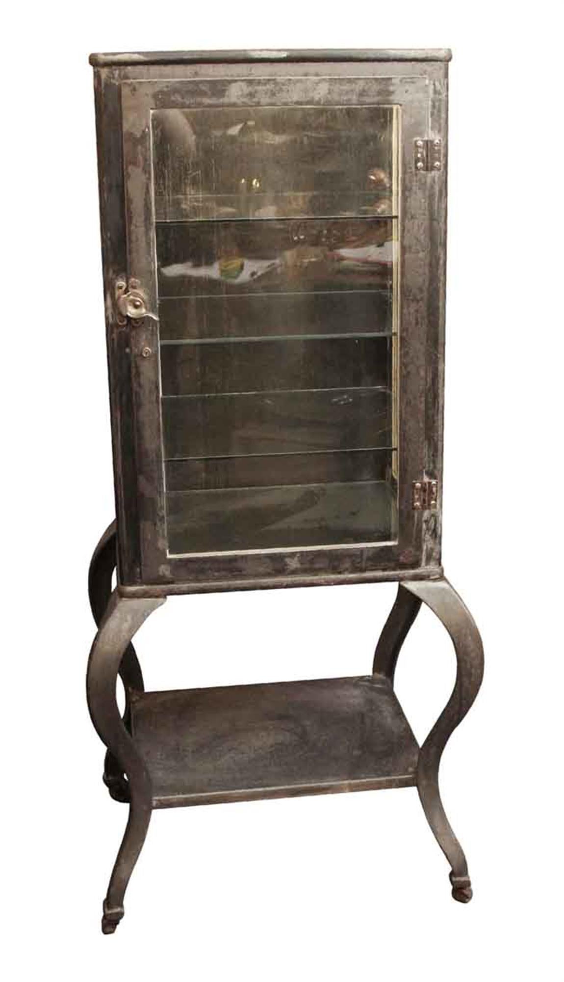 Highly sought after 1930s antique American made cold rolled and cast steel medical supply cabinet with cabriole legs. There are three sides of glass and three glass shelves. This has been stripped and lacquered. Great for display or for bath or