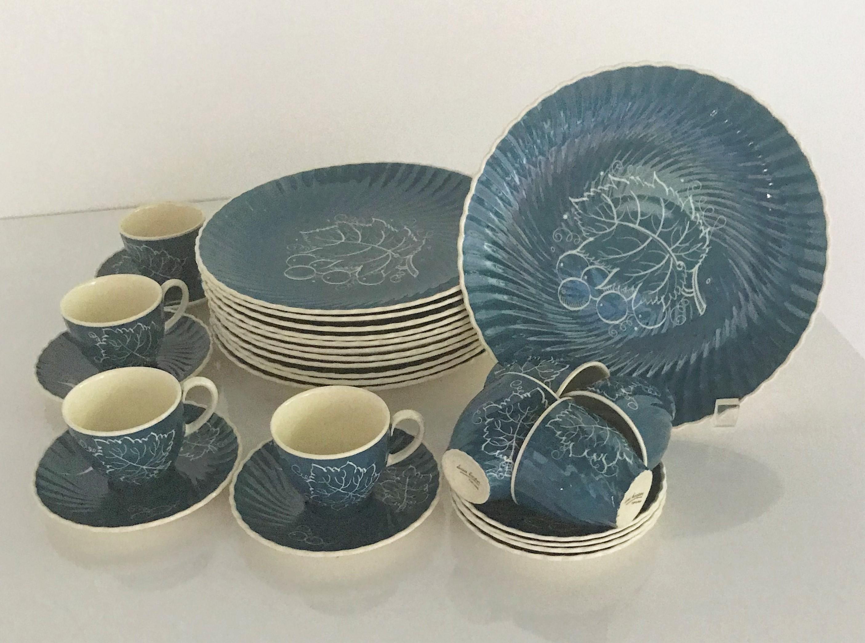 Susie Copper's 1930s Breakfast / Luncheon set of 8 Demitasse cups / saucers and 12 plates in blue background and white hand painted underglaze decoration of Grape Leaves and Grapes. The plates' and saucers' rims with a swirl or scalloped pattern.