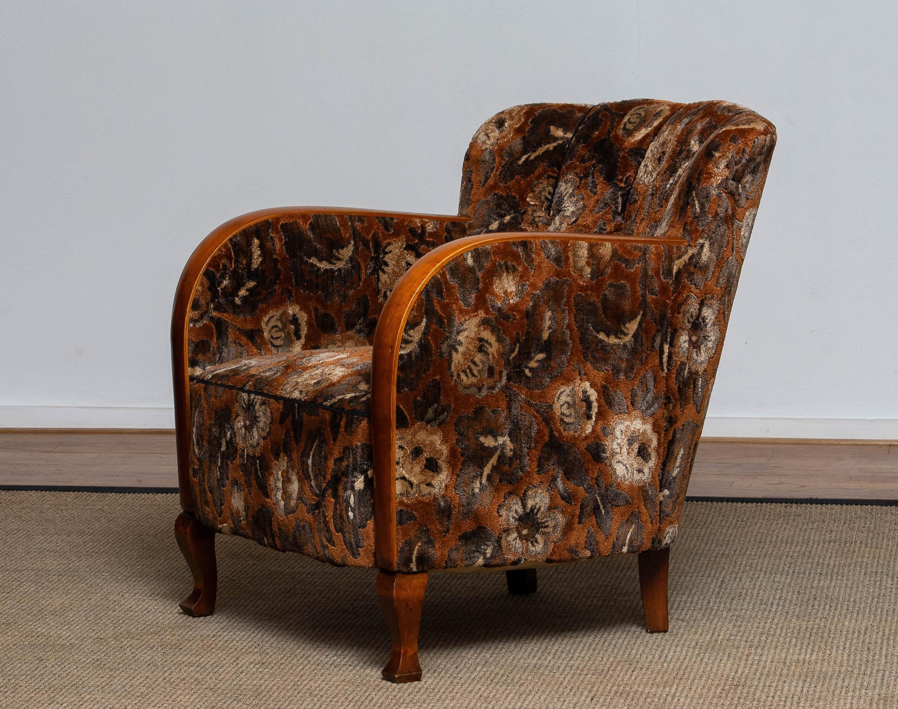 Beautiful Art Deco 1930's armchair / lounge chair upholstered with rust colored jacquard velvet from the '50s.
The armrests are made of satin beech. Allover the chair is in good and clean condition.
Sit comfort is excellent.

  