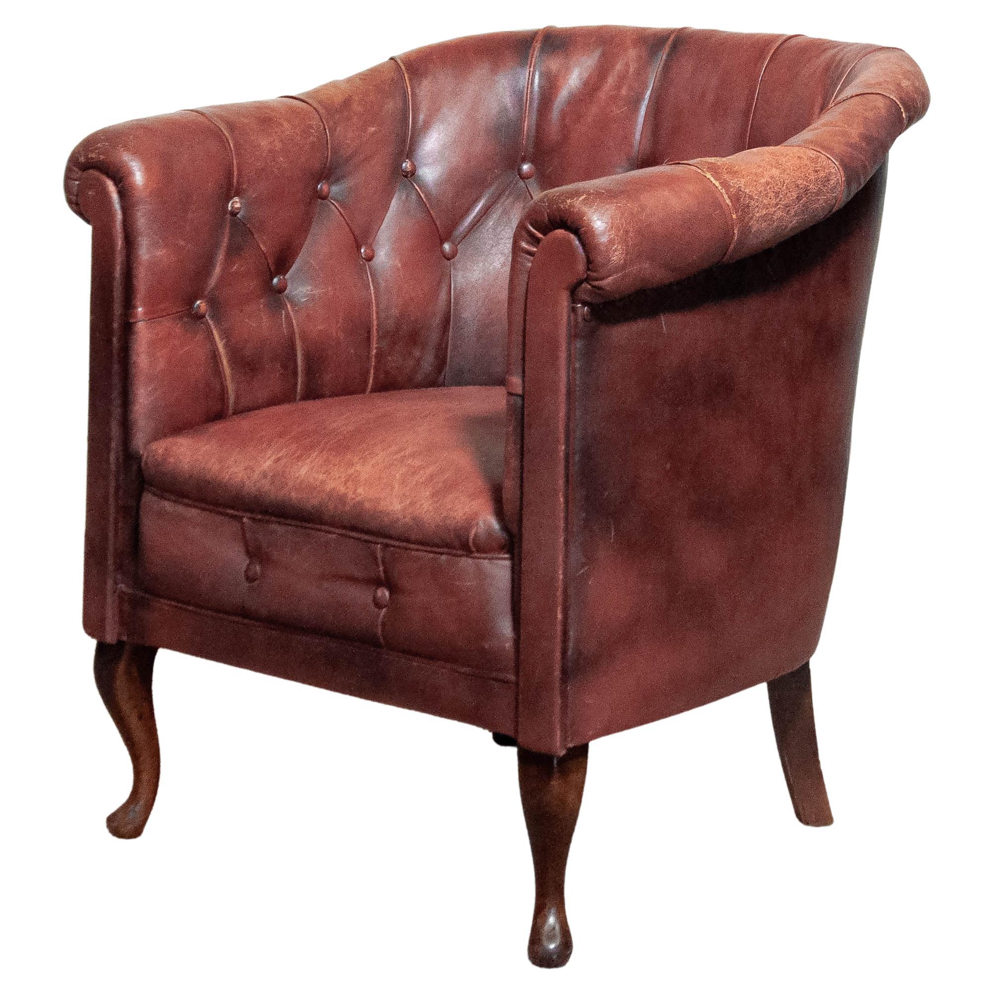 A beautiful 1930s Swedish Chesterfield club chair, featuring deep button-tufted leather upholstery with a rich, aged patina. The chair has been fitted with new webbing for enhanced durability, while the worn armrests add to their vintage charm.
