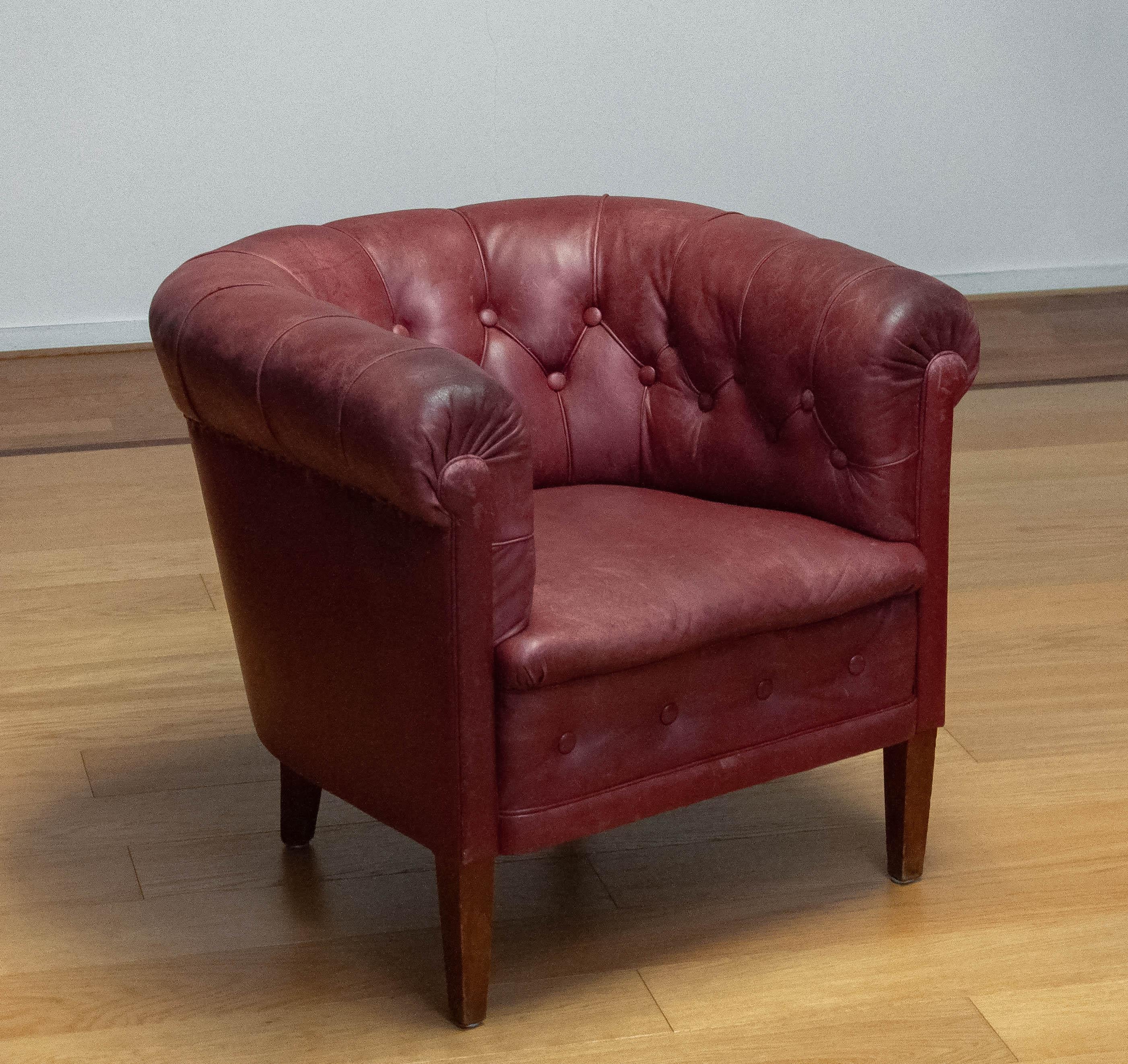 Magnifique fauteuil club rouge cramoisi fabriqué dans les années 1930 en Suède. La chaise est toujours en état d'origine et donc le cuir a une grande patine vraie les années. Le cuir est en bon état et encore très lisse. Les ressorts, les sangles