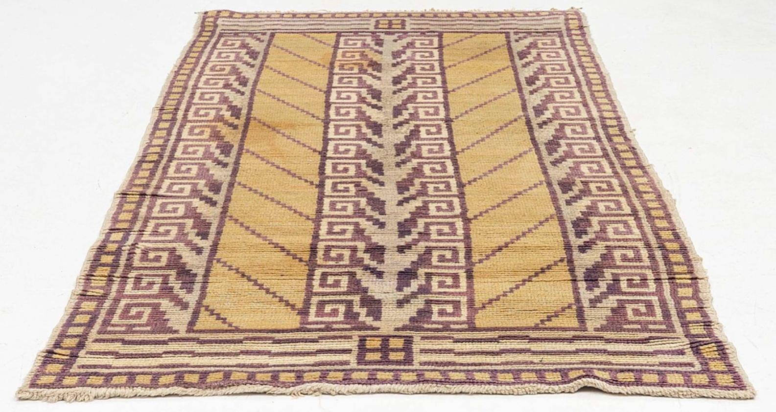 Magnifique tapis suédois des années 1930.
Le fond de la pile est d'une couleur moutarde pâle avec une bordure décorative en bloc avec un motif de clé grecque violacée à l'intérieur et s'étendant verticalement au centre.

Un tapis de taille