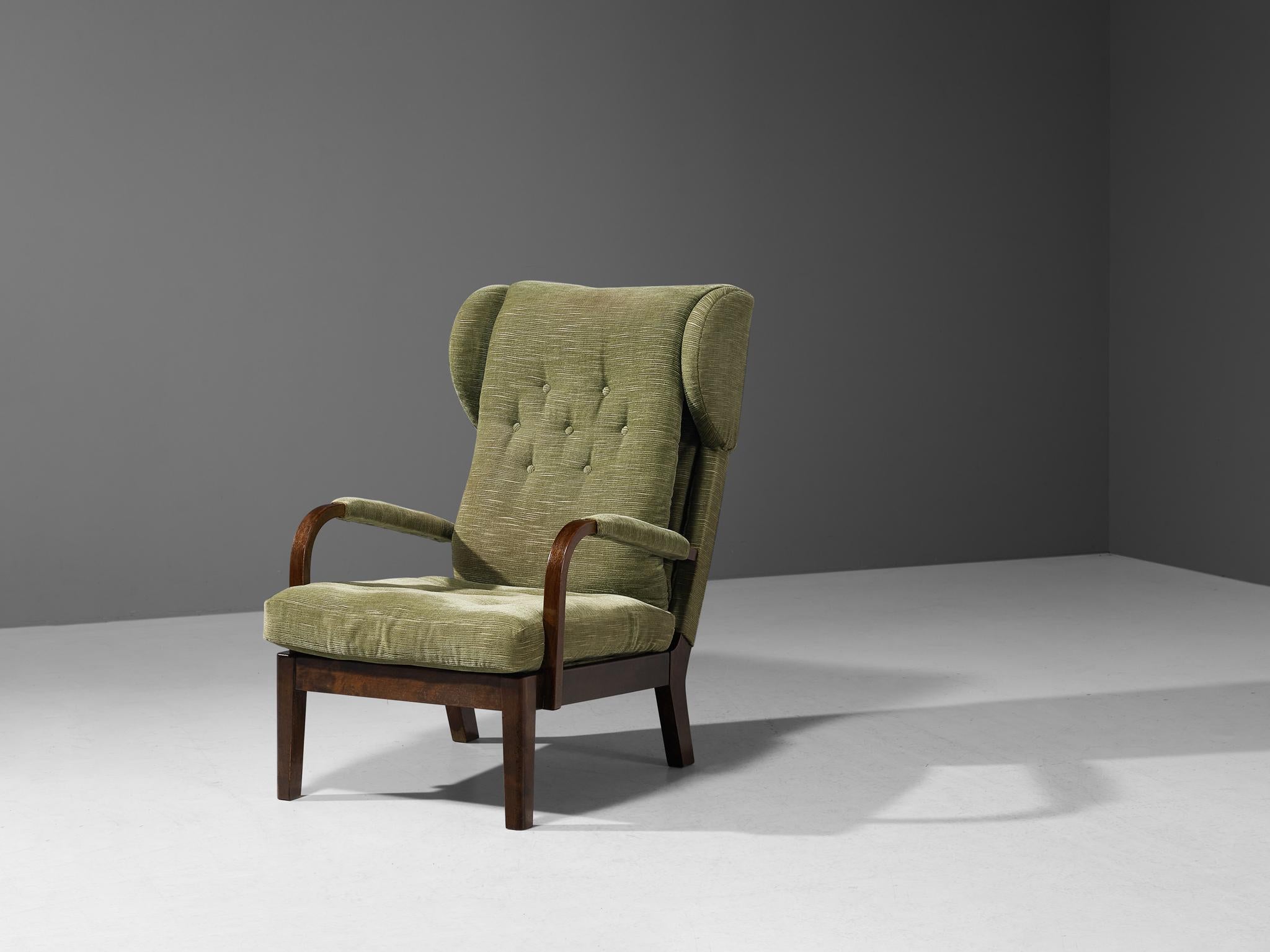 Sessel, Stoff, Buche, Metall, Schweden, um 1930

Dieser Loungesessel basiert auf einer soliden Konstruktion, die sich durch feine Linien und Formen auszeichnet. Die Rückenlehne wirkt durch die längliche Form und die großen Ohren, die die Kissen auf