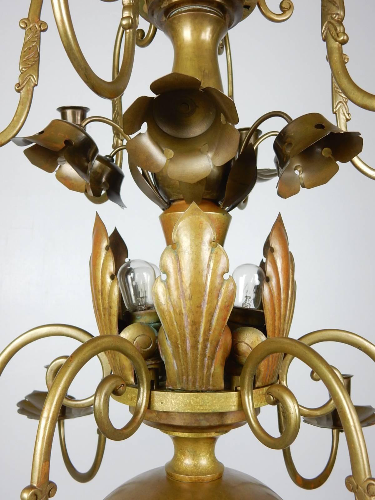 Fabulous 1930s Swedish chandelier. Sculpted organic brass floral motif.
12 candle arms and six center candlestick bulbs make this both a candelabra and chandelier.
Beautiful aged patina on brass. Signed 