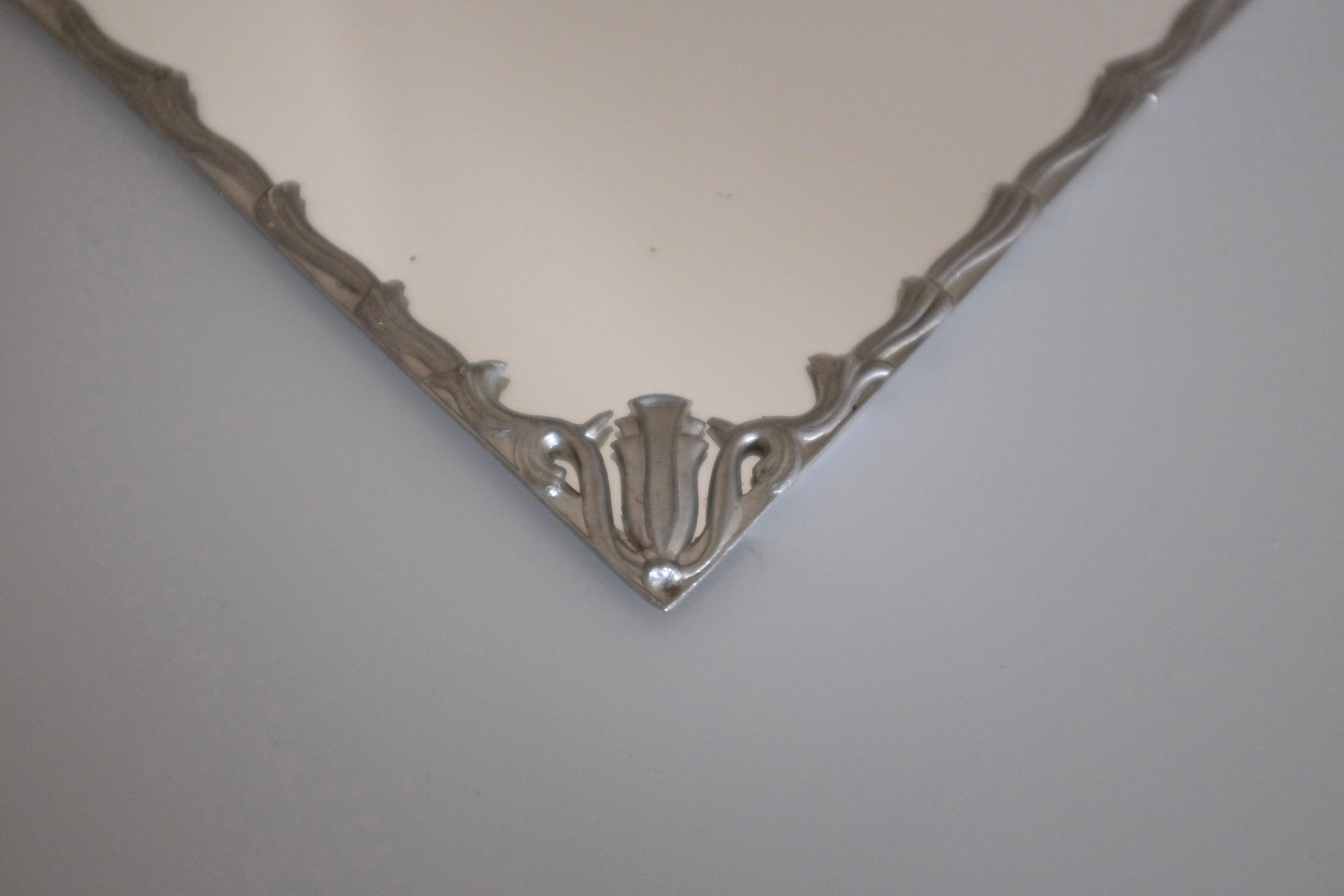 Small square shaped vintage Swedish Modern Pewter Mirror with decorative organic flower and leaf decoration around the border. Hanging on the side with vintage glass it is a very charming mirror. From around the the 1930s. Age appropriate wear and