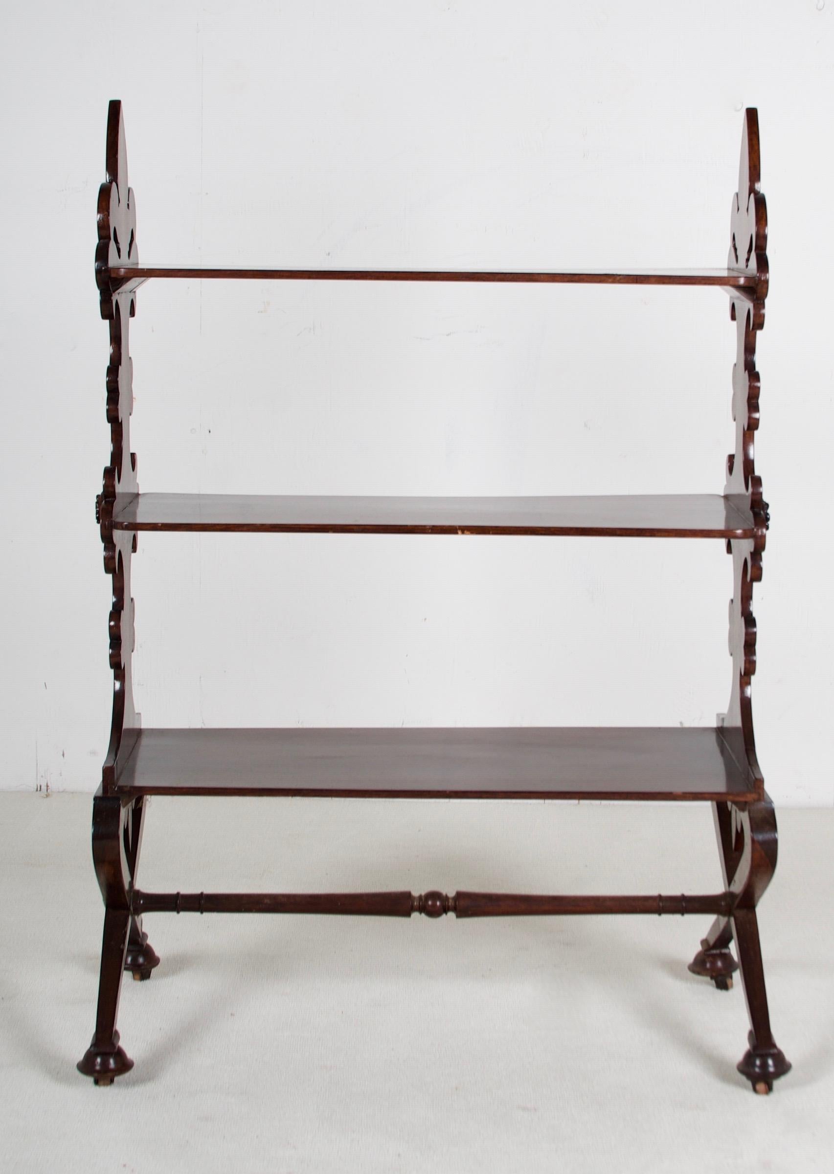 A lovely, Fleur d Lis decorated mahogany Etagere with X style supports on casters.
The craftsmanship is quite fine and well detailed. 
Belle Epoque, 