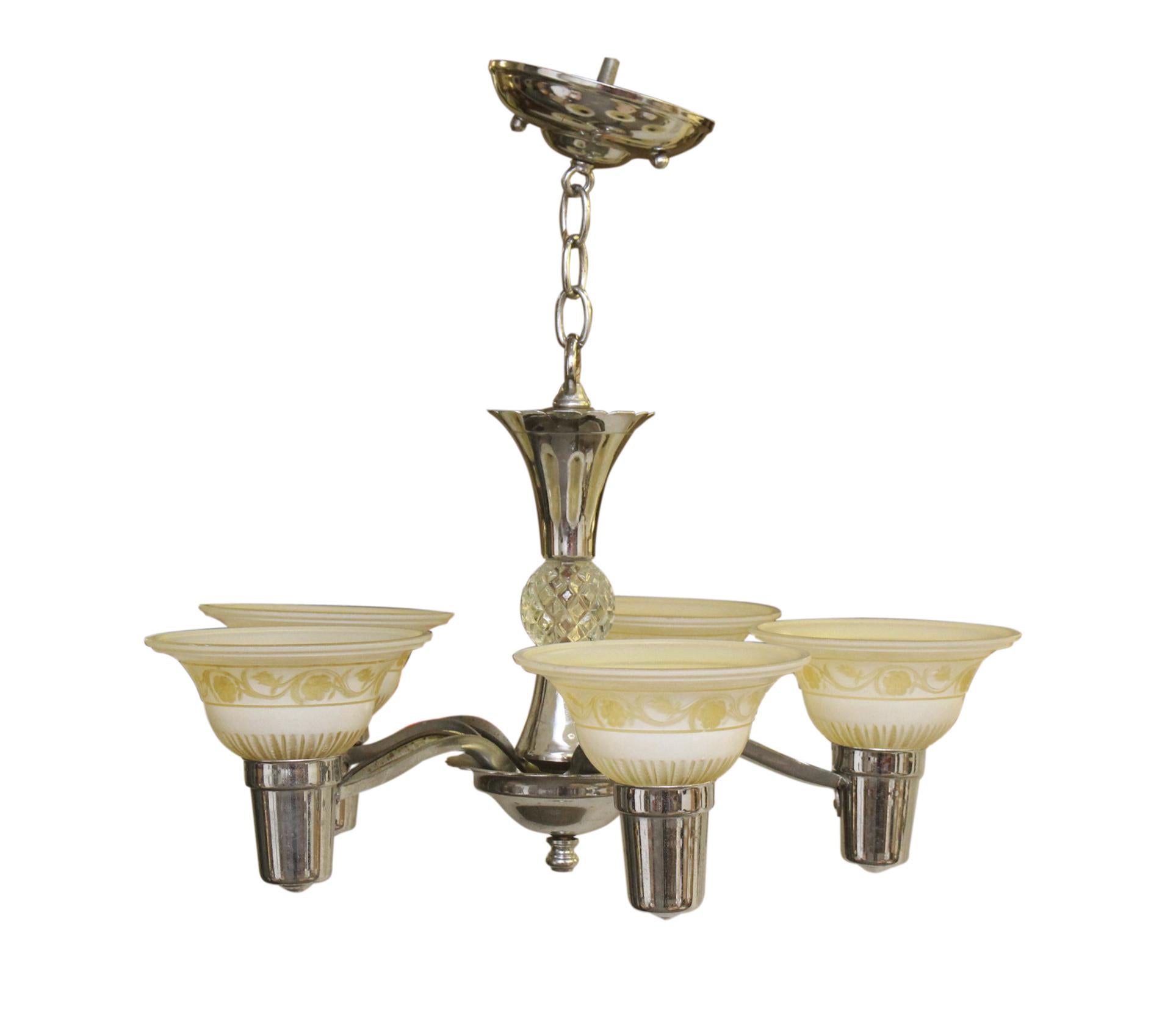 Lustre des années 1930 en laiton nickelé de style traditionnel avec des abat-jours en verre clair et jaune gravé. Cette lampe nécessite cinq ampoules standard E-26 à culot moyen. La restauration comprendra jusqu'à 3 pieds de chaîne. Nettoyé et