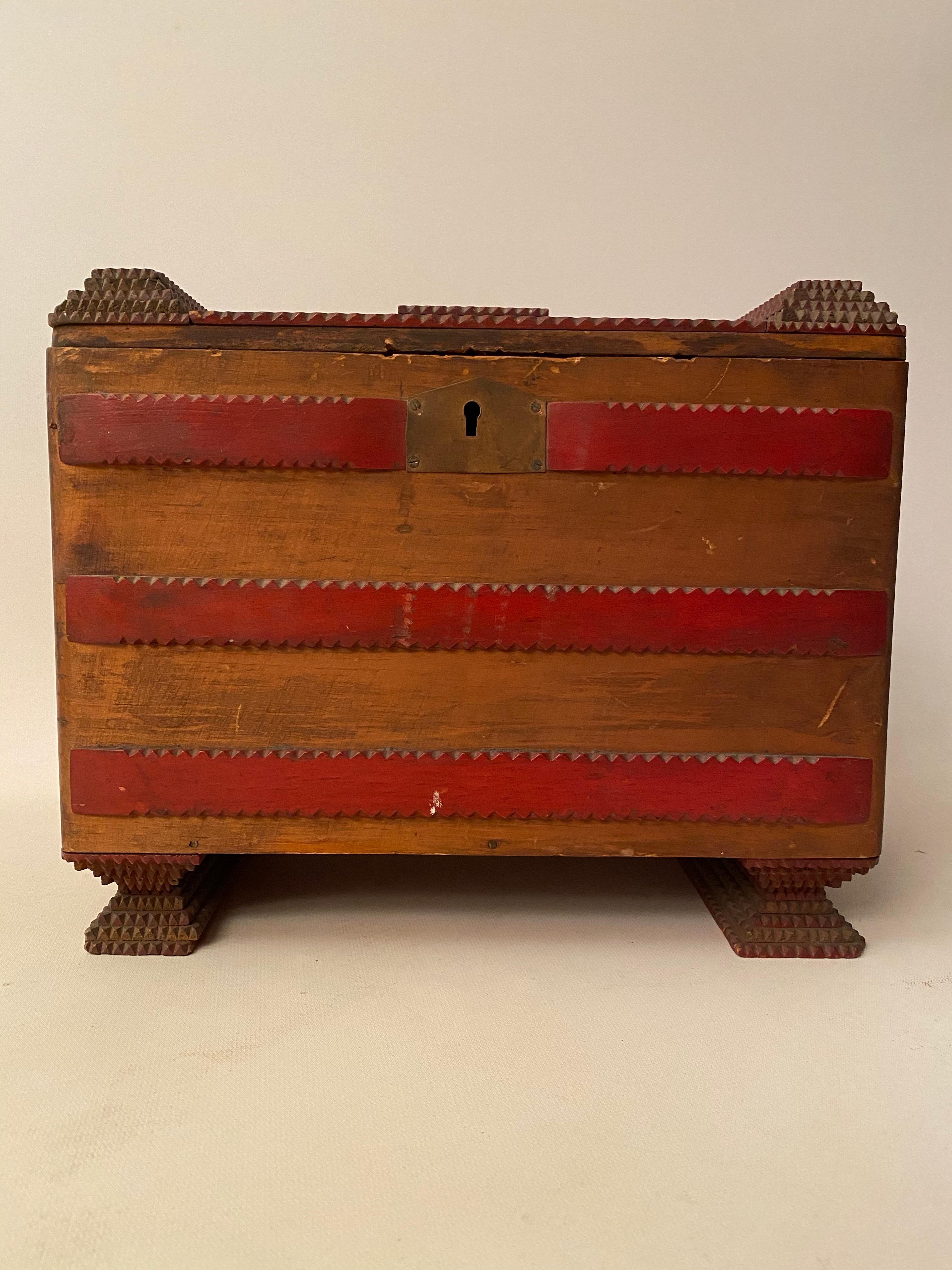 Tramp art box, circa 1920-1930, made of Victor cigar boxes and scraps of wood. Each decorative tiered layer and feet is notch carved. Wonderful two tone contrast of red and the warm brown tones of the natural wood boxes. The lock had been taken out.