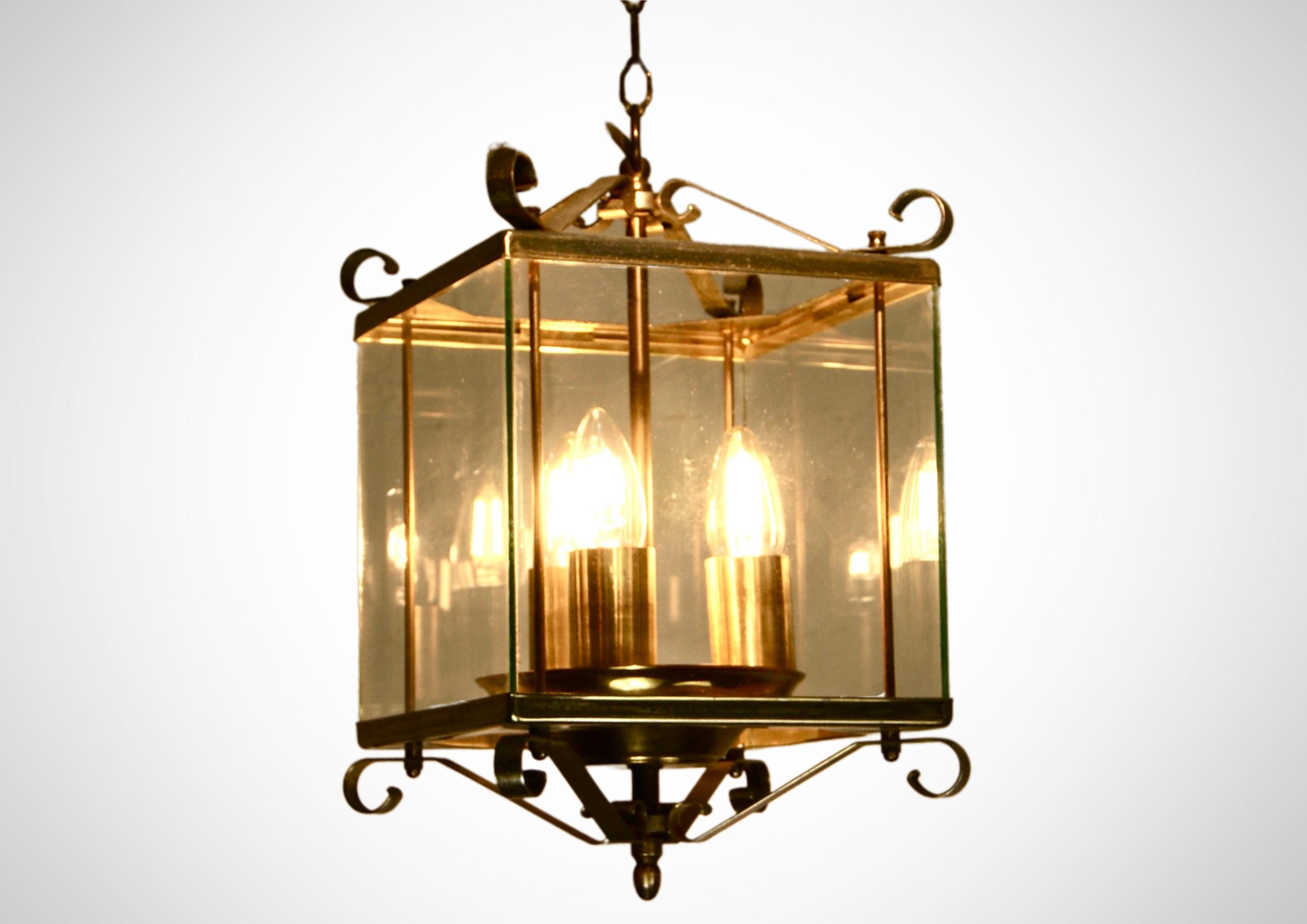 1930s glazed French Lantern. 
Art deco era ceiling suspension ceiling with 3 bulbs.
Gorgeous lantern with enough light to soften any dull room.
Solid brass frame with elegant flouncy scrolled edges and corners.
The chandelier is shaped like a bird's