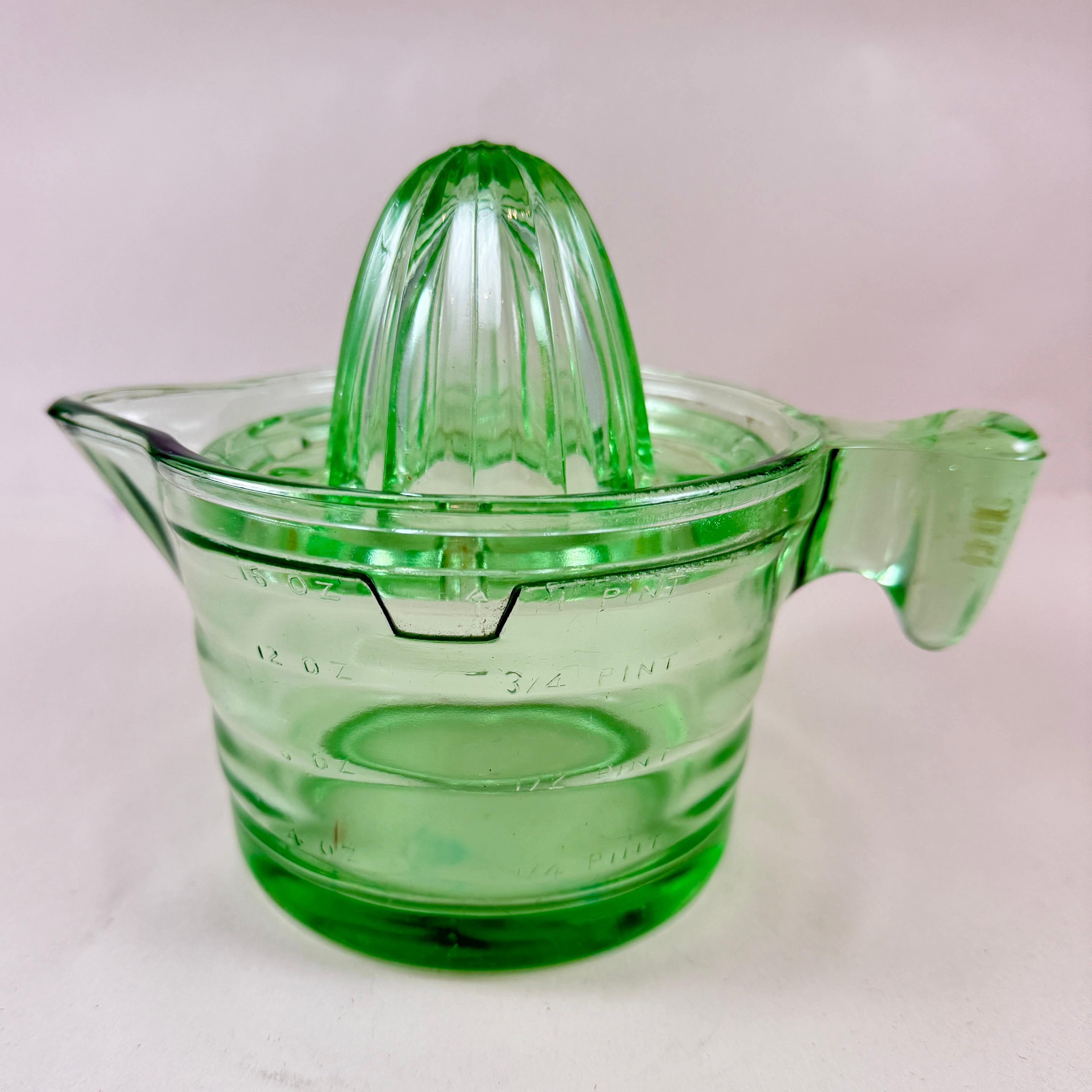 A green Uranium glass citrus reamer or juicer set with a bottom pitcher showing volume measurements, attributed to US Glass Company Glass – circa 1930s.

Uranium reamers and juicing sets typically have a greenish hue and glow brightly under