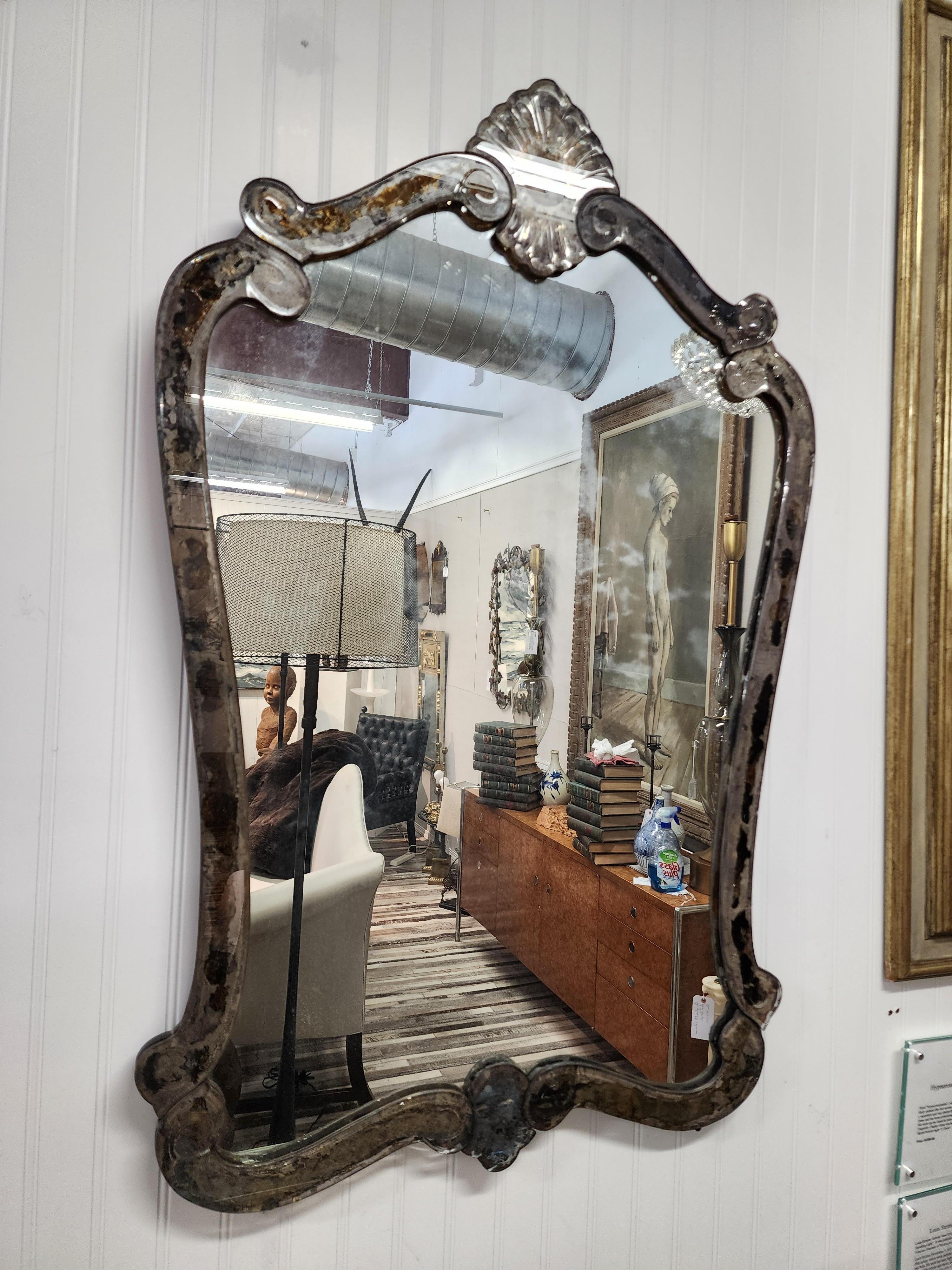 A very beautiful and reserved Venetian glass mirror. Simple and clean with some of the most beautifully patinized mirror glass I have seen.
Over time the silver to the frame of the mirror has turned into gorgeous warmth and weathered tones.