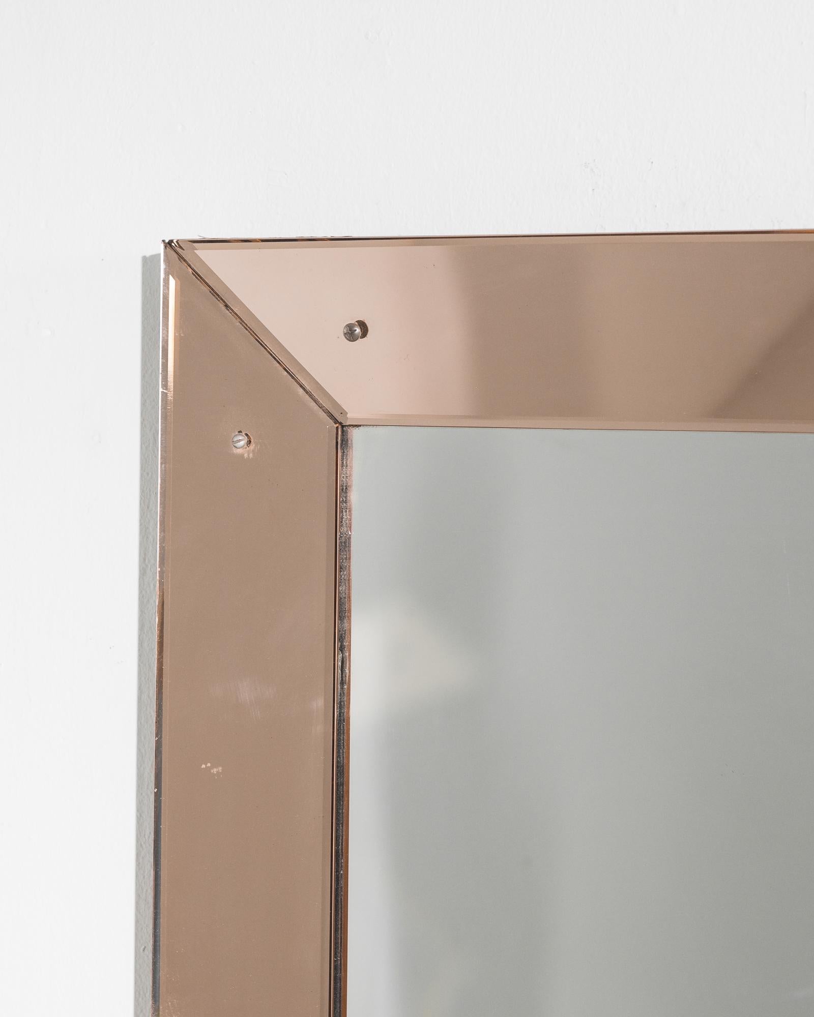 This glass frame mirror was crafted in Italy, circa 1930. Updated with a new mirror in our atelier, the beveled frame displays an elegant rose tint and an immaculate sheen. The cleanness of the lines exhibit the glamor and style innate to the