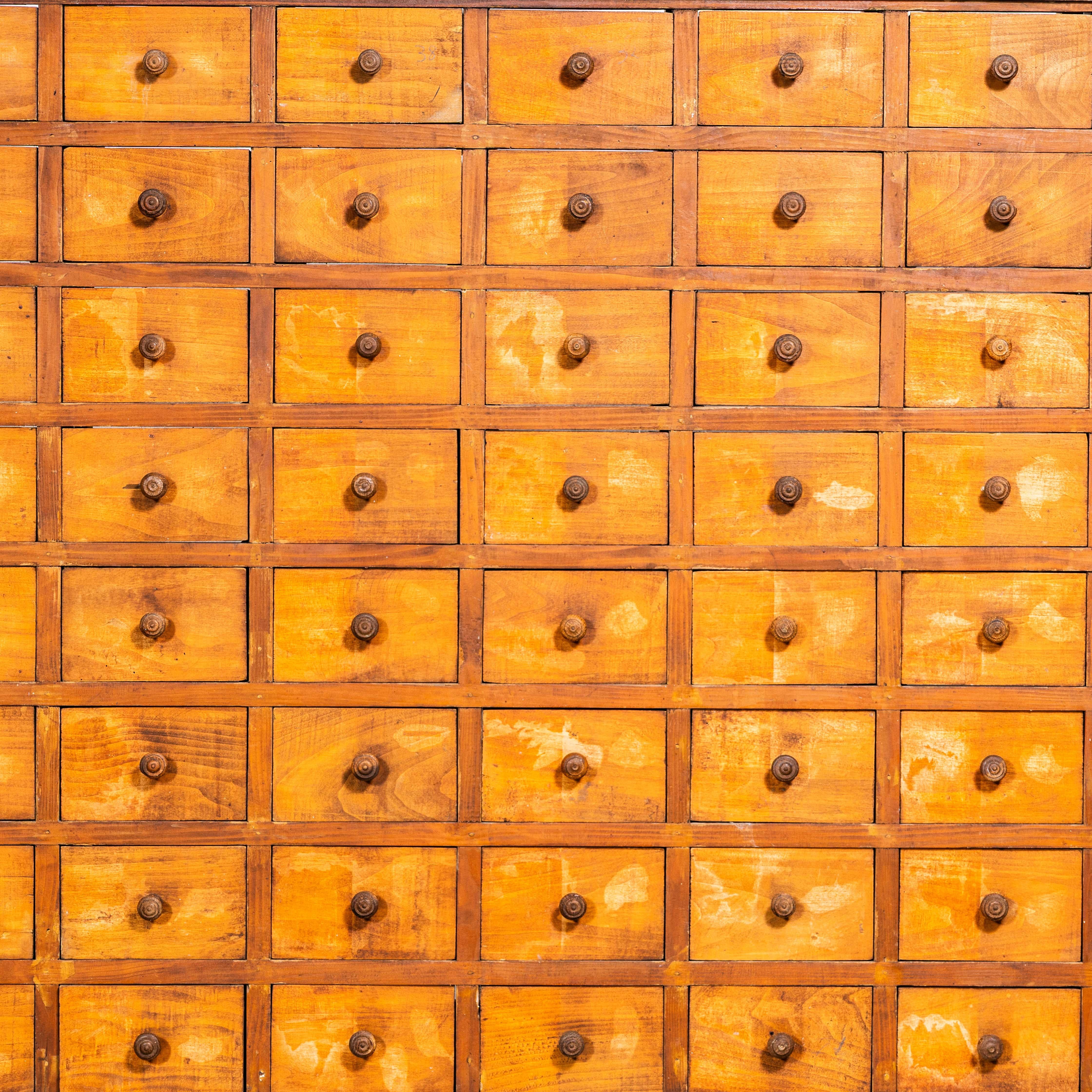 1930’s Very Large Bank Of Seed Drawers – One Hundred And Twelve Drawers. Massive bank of drawers sourced in France it was used to hold seed packets. The cabinet is made from a mixture of pitch pine and fruitwood. We bought it as is, without a back.