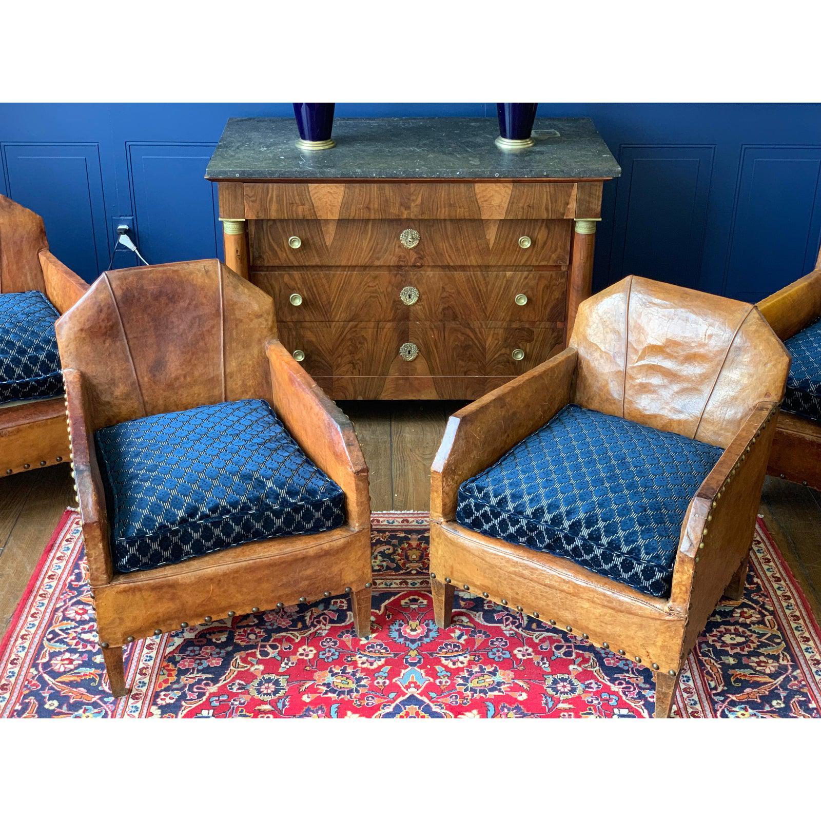 Set of 4 Art Deco leather chairs are from Paris, France, circa 1930. Cushions reupholstered with Christian LaCroix blue velvet fabric.
The chair features their original leather with a distressed and aged patina. The leather has wear and tear water
