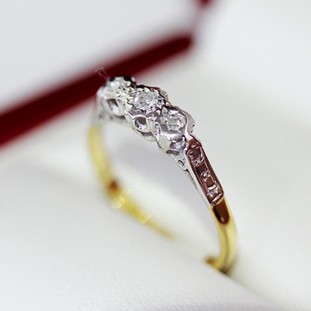 18ct Yellow Gold and Platinum 3 stone Diamond ring. 3 single cut Diamonds illusion grain set in platinum top with platinum illusion engraved swept up shoulders on a yellow gold 1/4 round 2.15mm band.

The ring contains:

Three Illusion Set natural