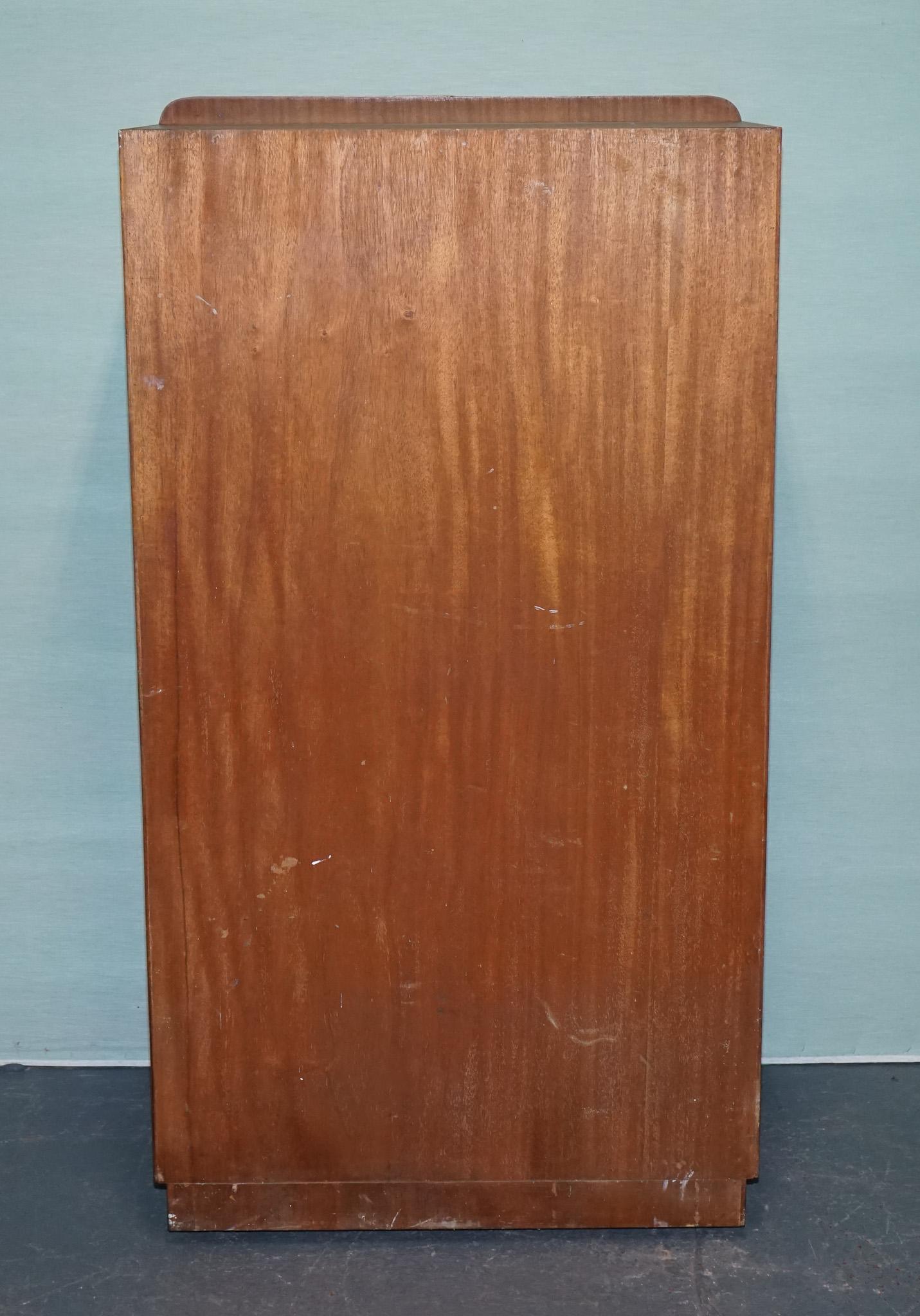 
Antiquariato di Londra



Un bel mobile Art Deco britannico con ante in radica di noce incorniciate da una fascia trasversale più chiara e angoli morbidamente arrotondati. La base a zoccolo pulita e i sottili tiranti verticali conferiscono al pezzo