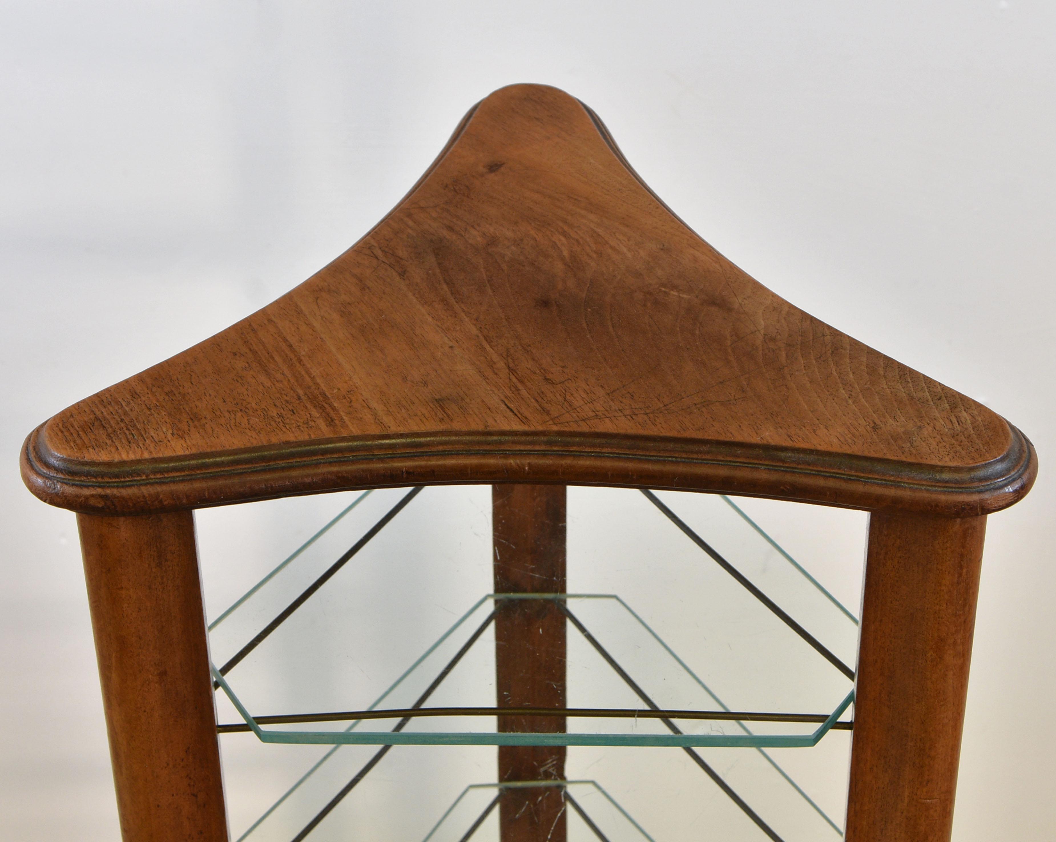 A lovely upright walnut shop display stand of triangular form with eleven glass shelves. Probably French. Circa 1930's.

The glass shelves simply sit on the brass supports.

Made in solid walnut, it is in good condition, showing a few marks and
