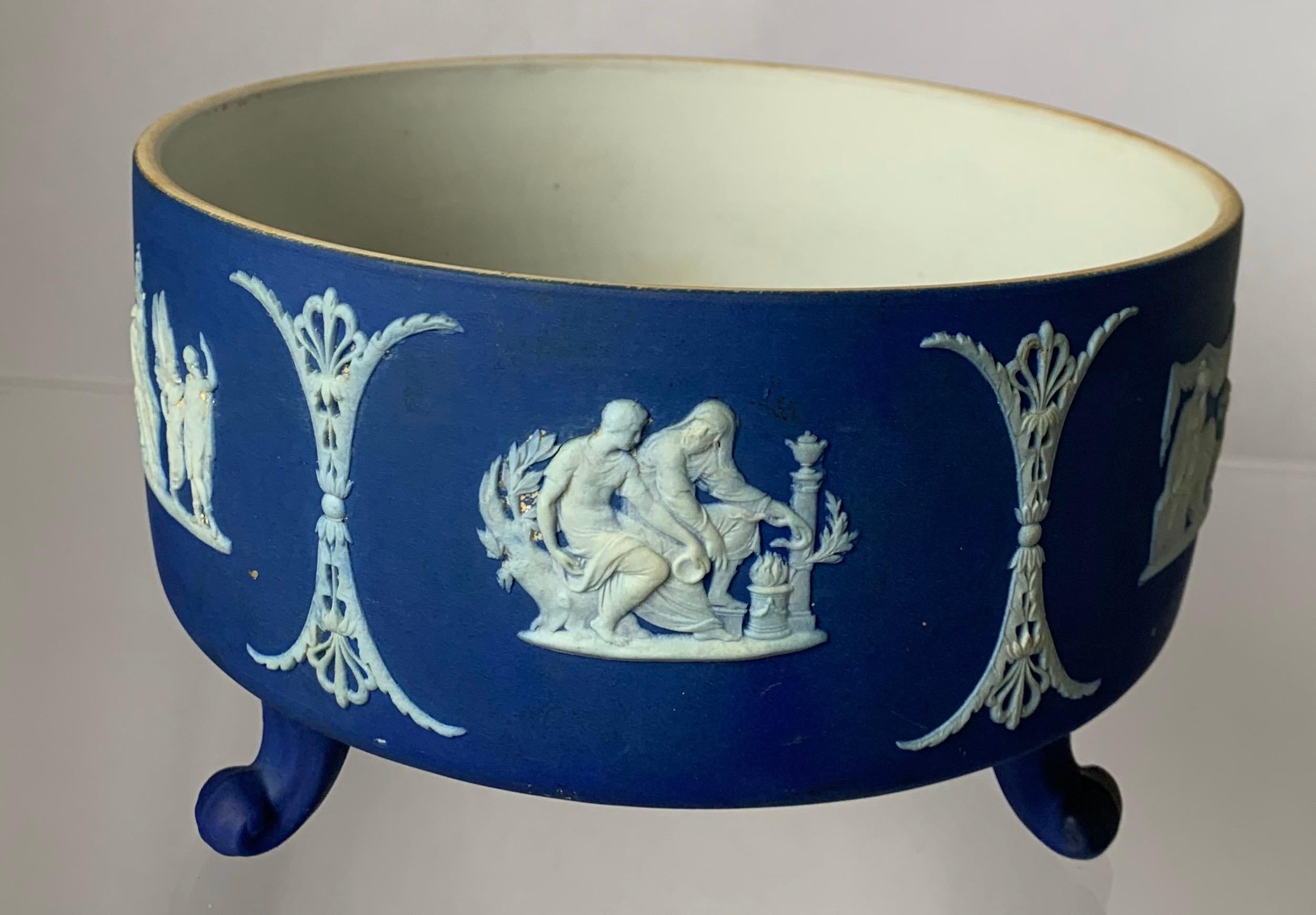 1930s Wedgwood jasperware footed bowl. Dark blue jasperware with all-over white neoclassical motif tripod footed base. Interior of the bowl is glazed. Bowl is stamped Wedgwood made in England on the underside.