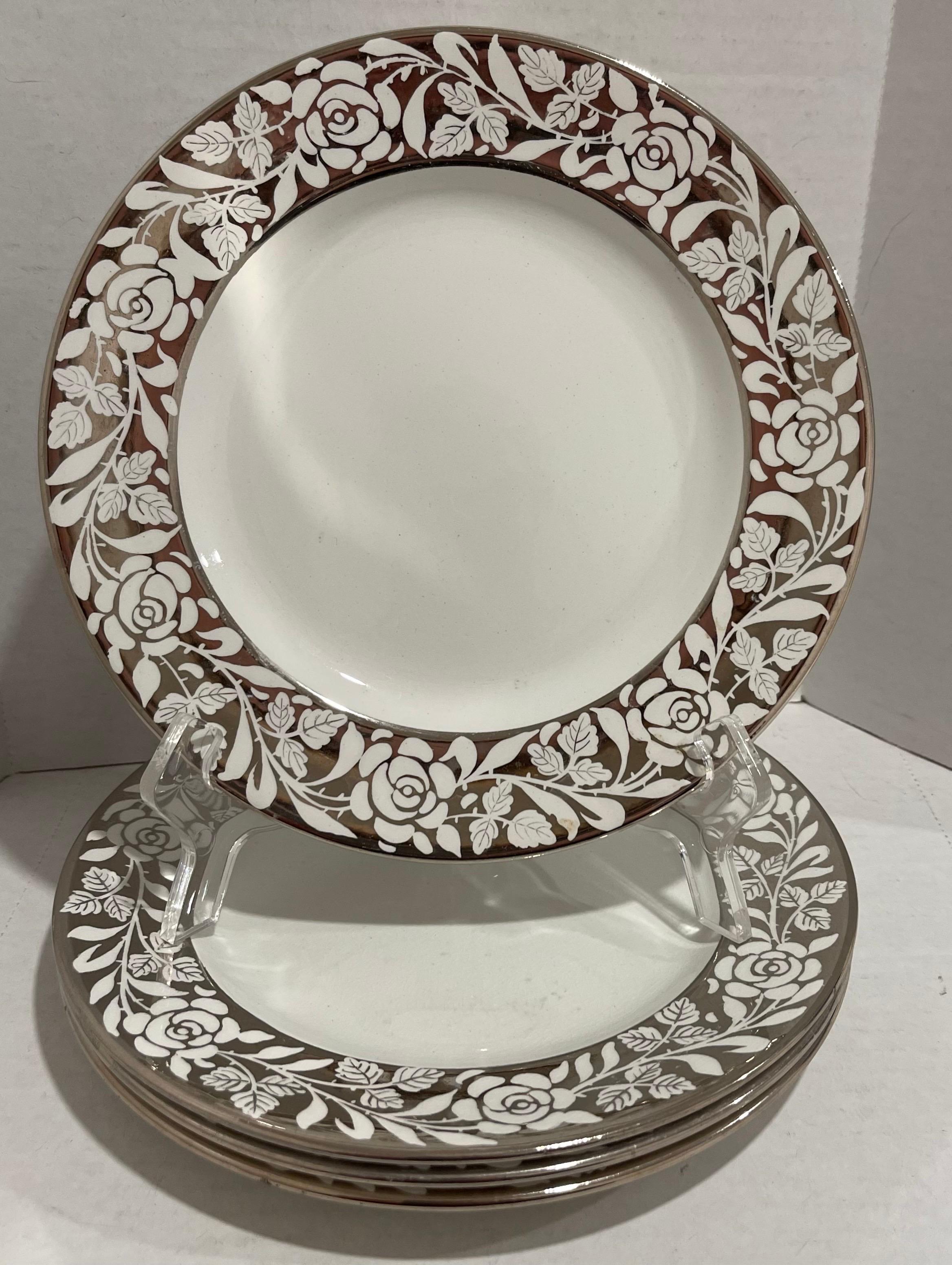 Set of four 1930s Wedgwood lustreware dessert plates. Silver floral lusterware design. Each plate is stamped Wedgwood Made in England. 

Plate stand is not included.