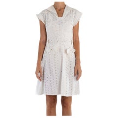 Petite robe en coton blanc à œillets et dentelle avec poches à nœud, années 1930