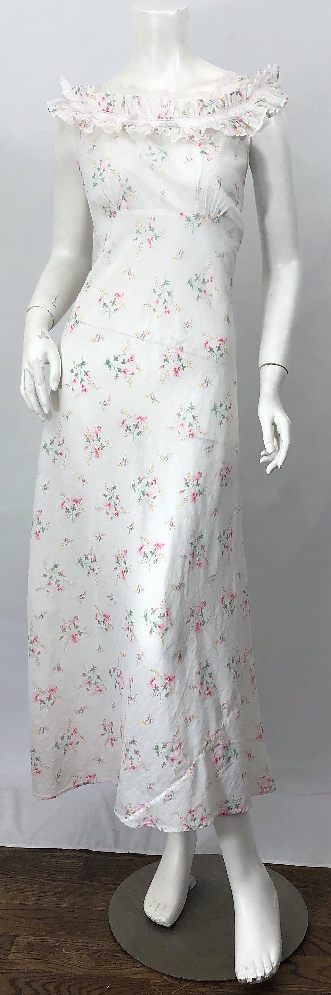 Beautiful 30s white flower print lightweight cotton voile bias cut sleeveless maxi dress! Features a stark white background with bouquets of flowers in vibrant colors of pink, yellow and green throughout/ Two layers of ruffles at the front neck add