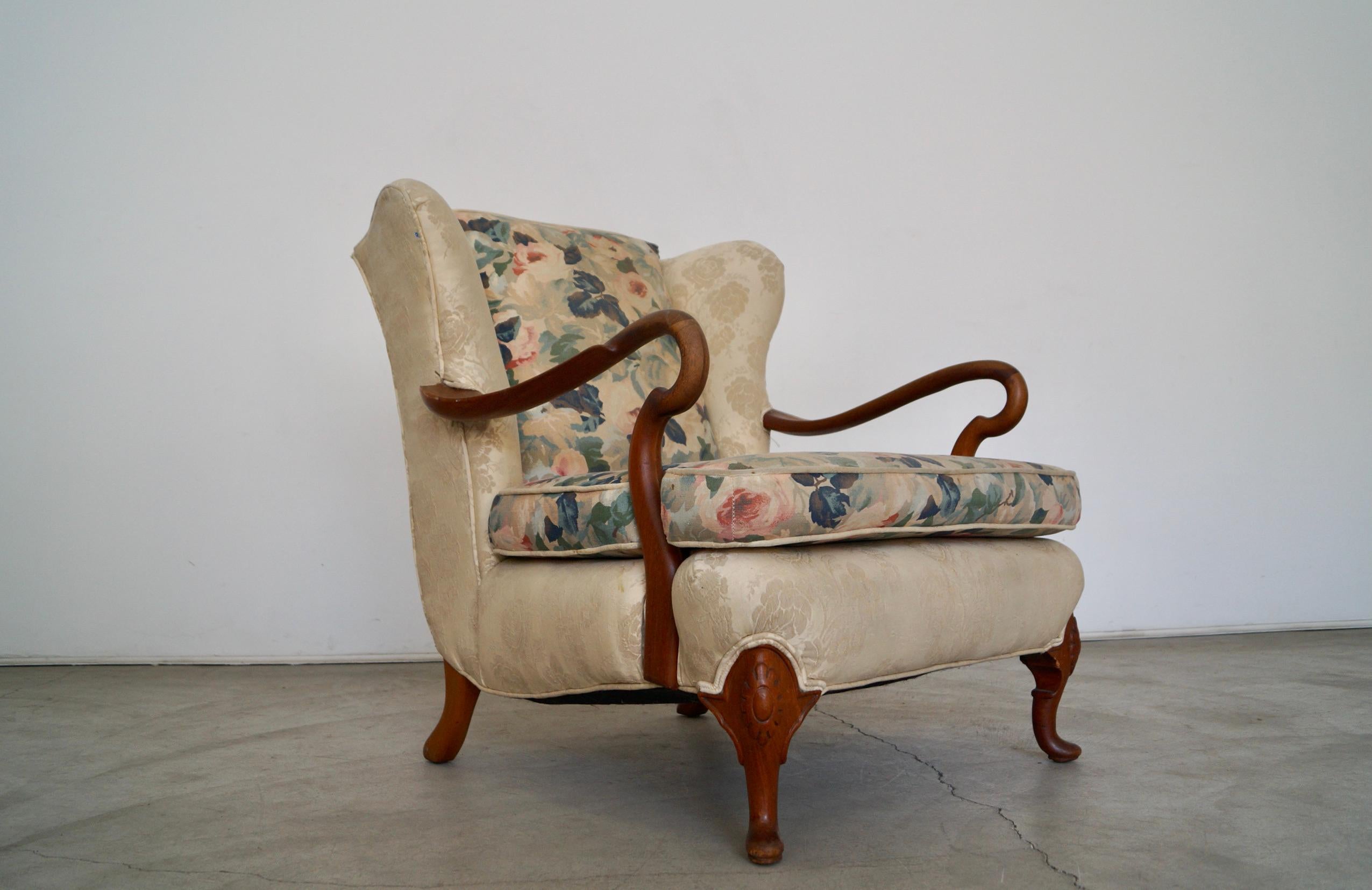 Vintage wingback lounge chair for sale. From the 1930's, and has an amazing frame and design. It has a silk upholstery with a floral linen backrest and cushion. It's a solid and well built chair and solid construction. It has solid mahogany arms