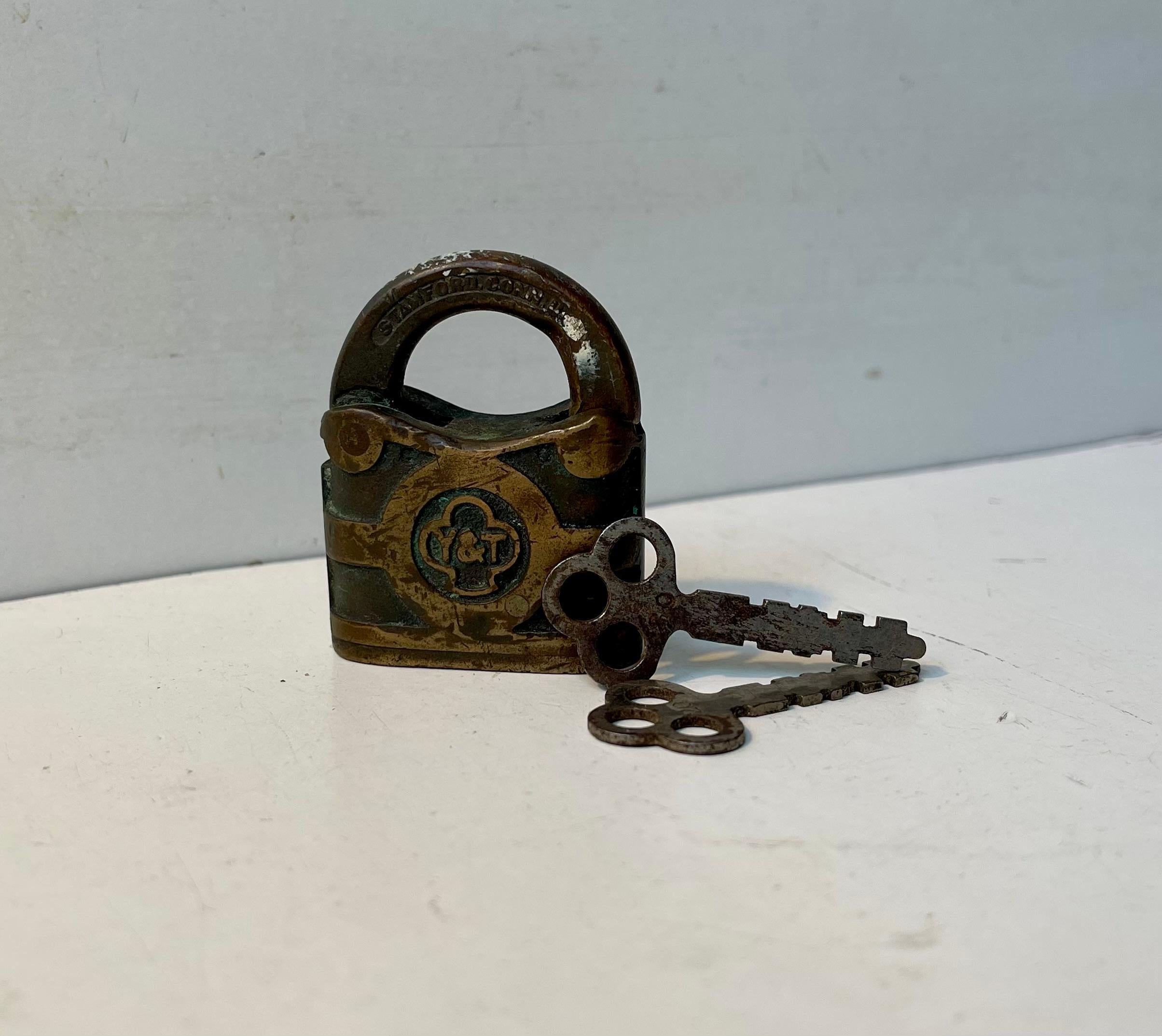 Un lucchetto Yale originale degli anni '30 con le due chiavi originali. Realizzato in ottone e bronzo con logo su entrambi i lati. Fuso e realizzato negli Stati Uniti. Costruita come un carro armato e con una grande patina intatta. Funziona bene ed